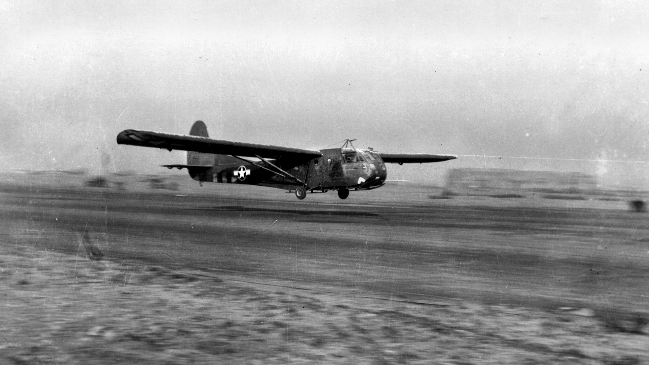 A CG-4A cargo glider of the 439th Trooper Carrier Group lifts off from an airfield in France to resupply besieged troops around Bastogne during the Battle of the Bulge, December 27, 1944.