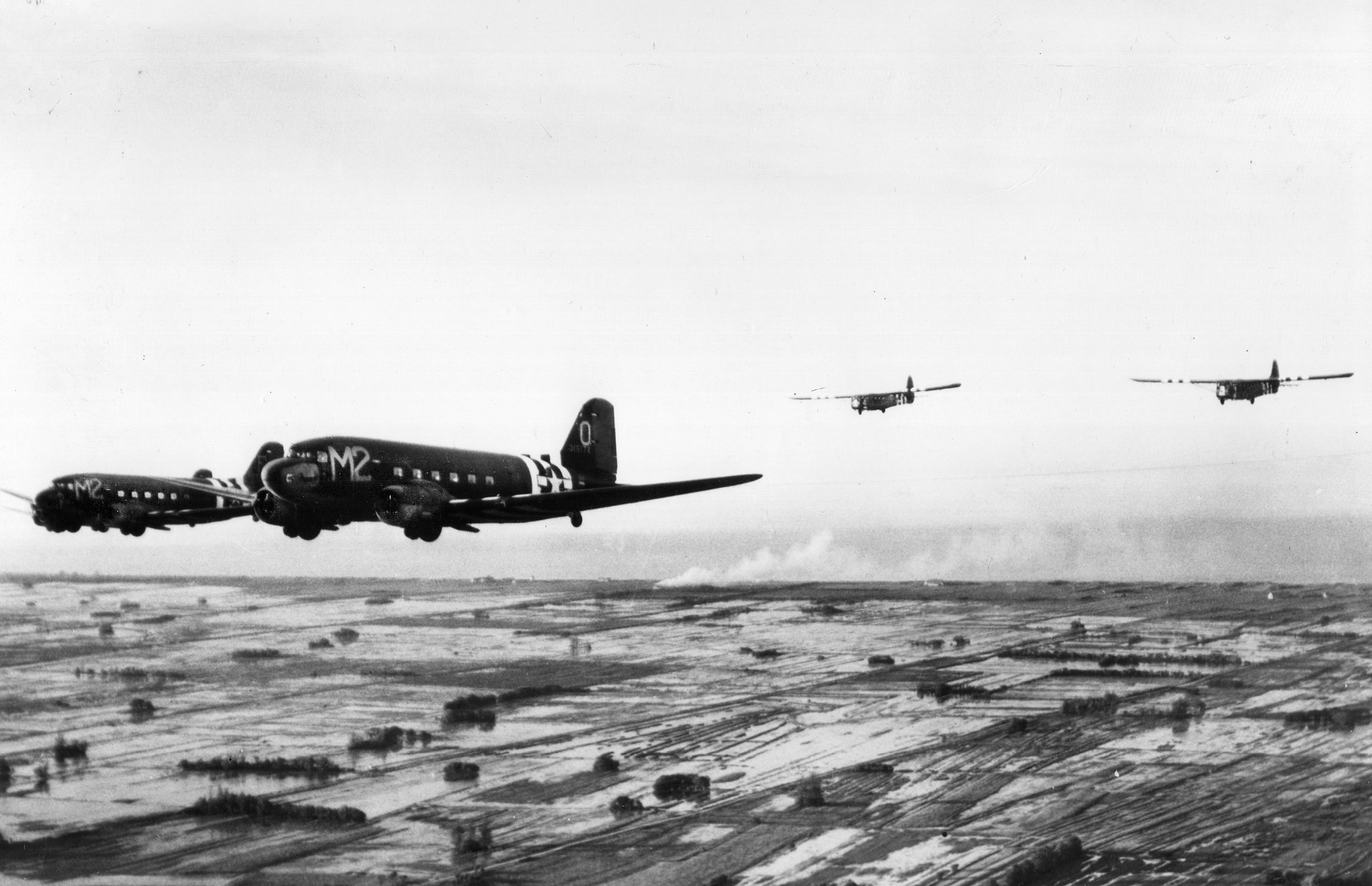 Two C-47s tow gliders to landing zones during the Normandy invasion, June 6, 1944. Nearly 900 British and American gliders were employed during the operation. 