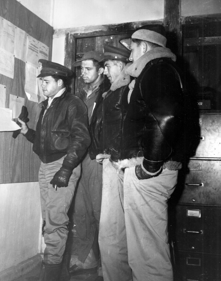 Checking “ceiling reports” is Operations Officer Lt. Jack O. McReynolds, Dallas, Texas, and a group of pilot officers.