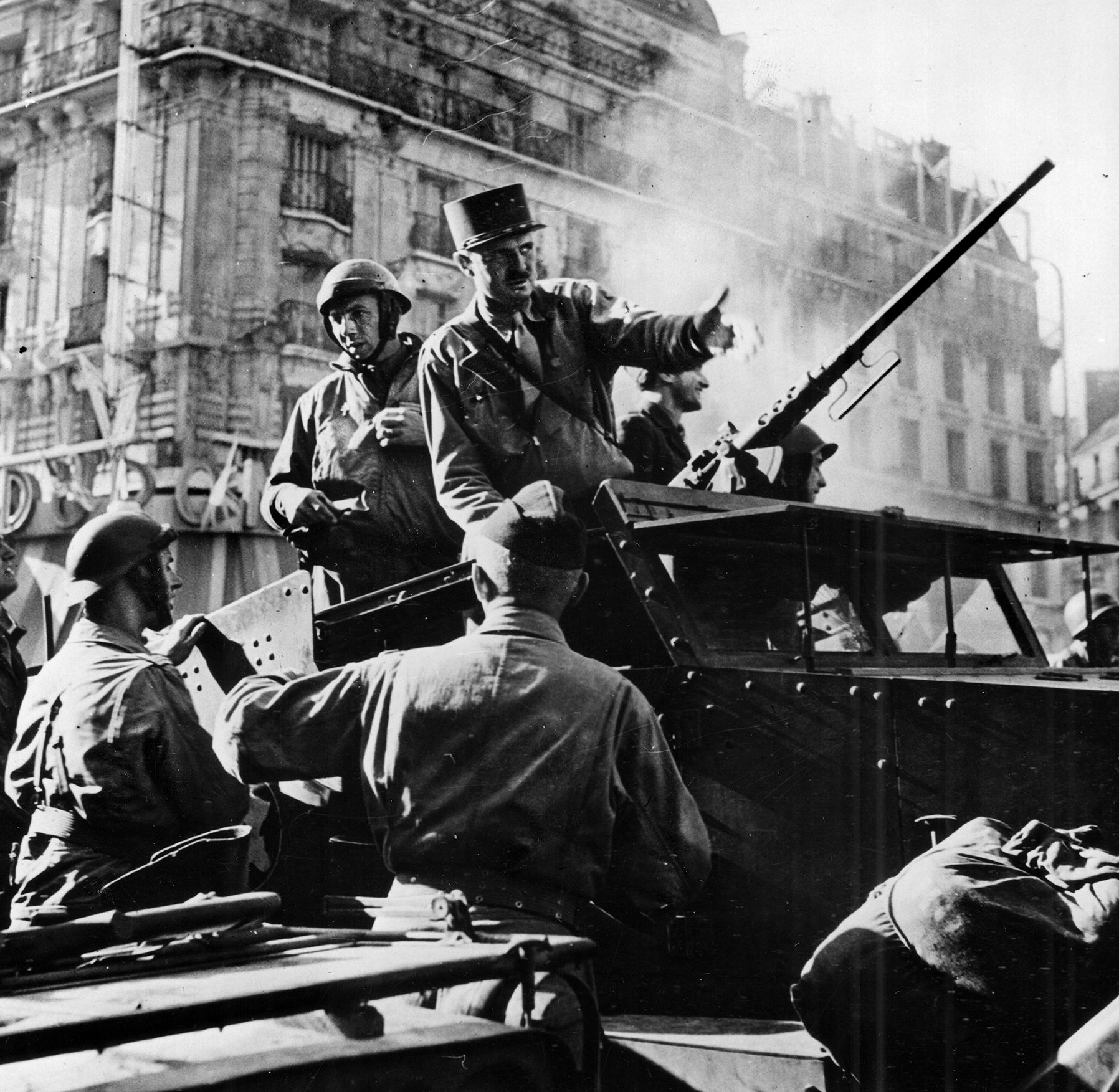 Oblivious to snipers and wearing his trademark kepi, Leclerc enters Paris on August 25, 1944, and issues orders from his halftrack on the Boulevard Montparnasse. 