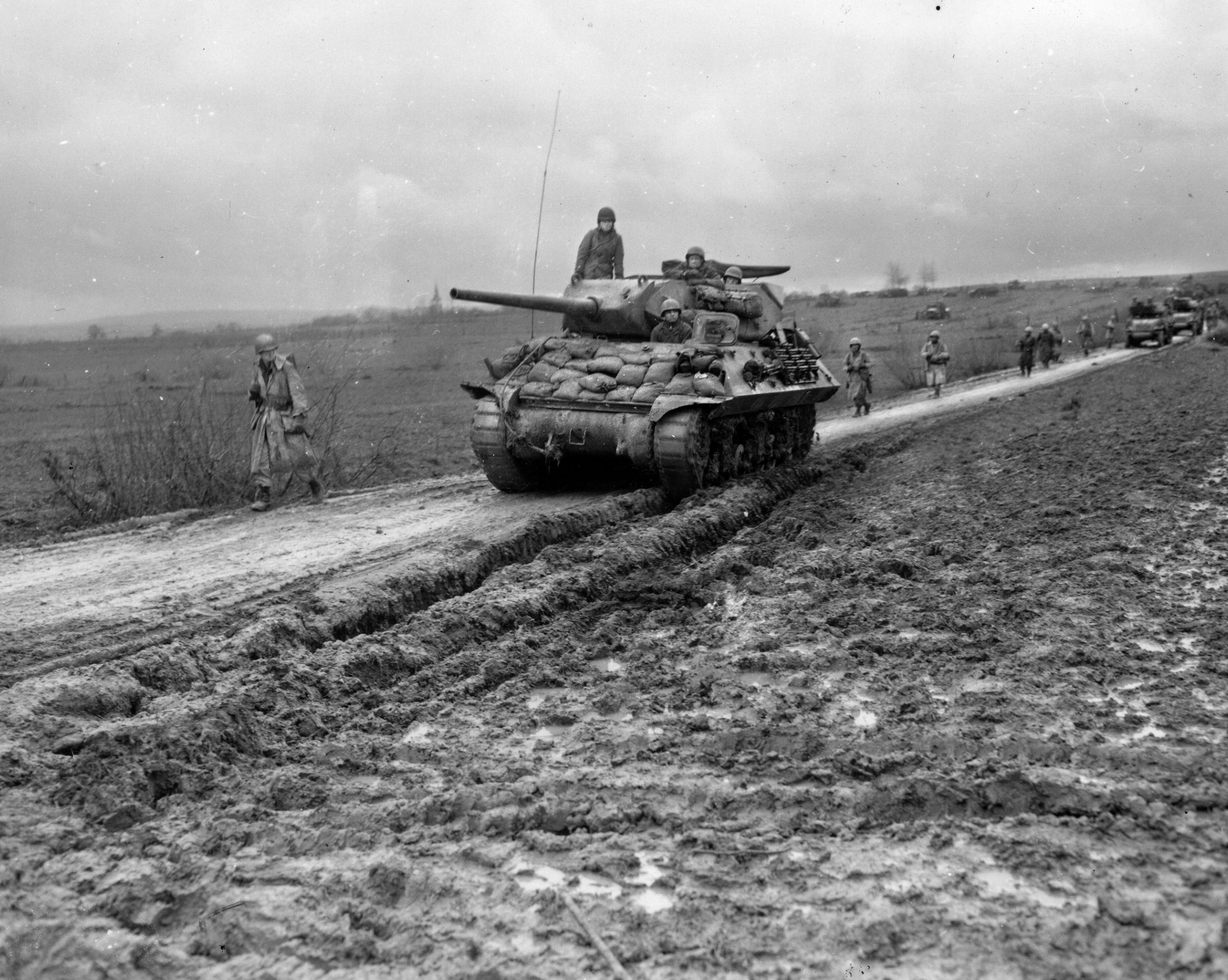 With winter coming on, an M10 Wolverine tank destroyer of Régiment Blindé de Fusiliers Marins, rolls down a muddy road toward the front near Halloville, France, November 1944.