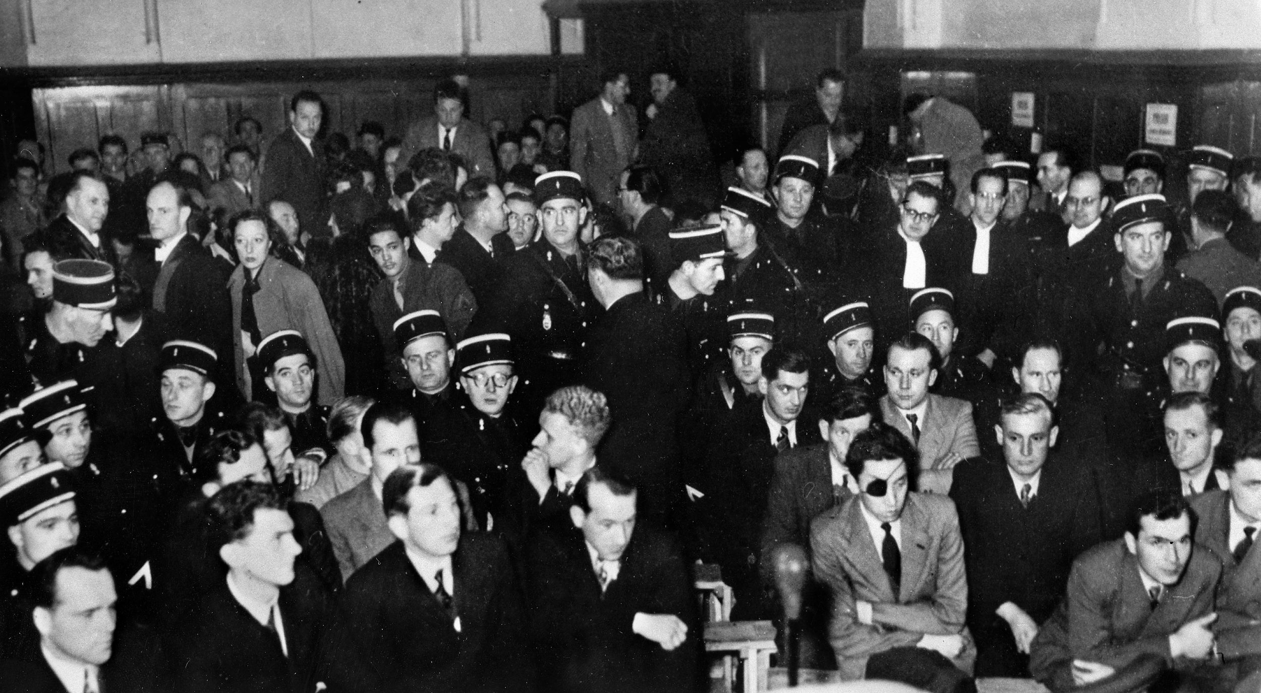 German defendants, lower right, listen anxiously to the evidence at the War Crimes tribunal at Bordeaux in 1953. Among them was the Alsatian George Boos, who decided to forsake his technically French heritage, volunteered to join the SS and chose, without remorse, to be tried as a German soldier.