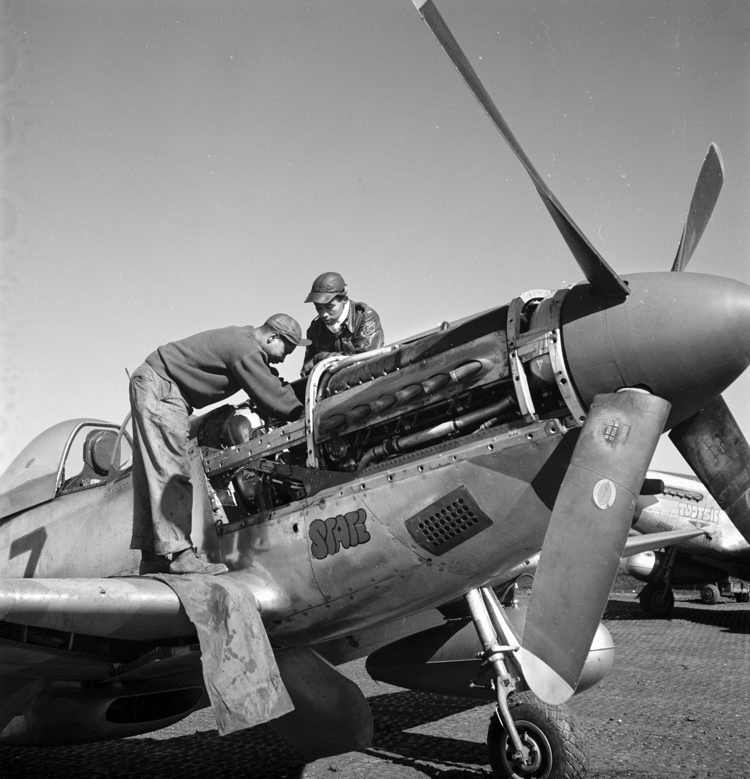 Lieutenant Roscoe Brown, right, observes as mechanic Marcellus G. Smith works on the engine of Brown’s P-51 Mustang “Tootsie" before a mission at the 15th Air Force Base at Ramitelli, Italy, March 1945.