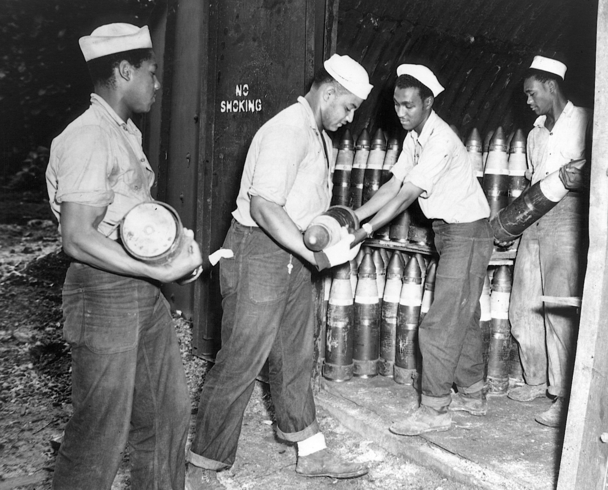 Navy men load an ammunitions bunker with 6-inch shells.