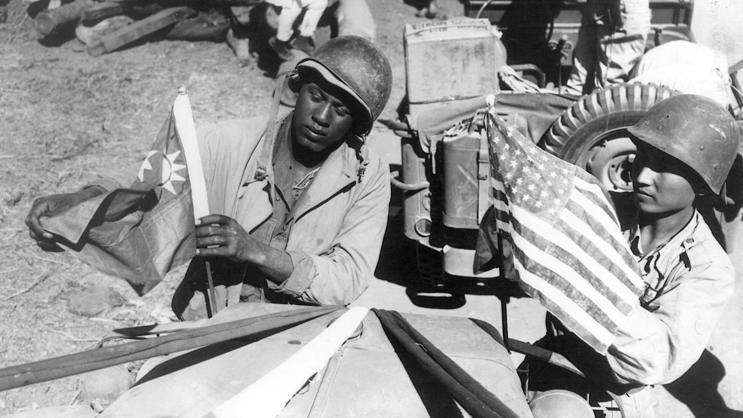 A U.S. Army soldier and a Chinese soldier put flags on the first convoy from China to India on the Stilwell Road. 