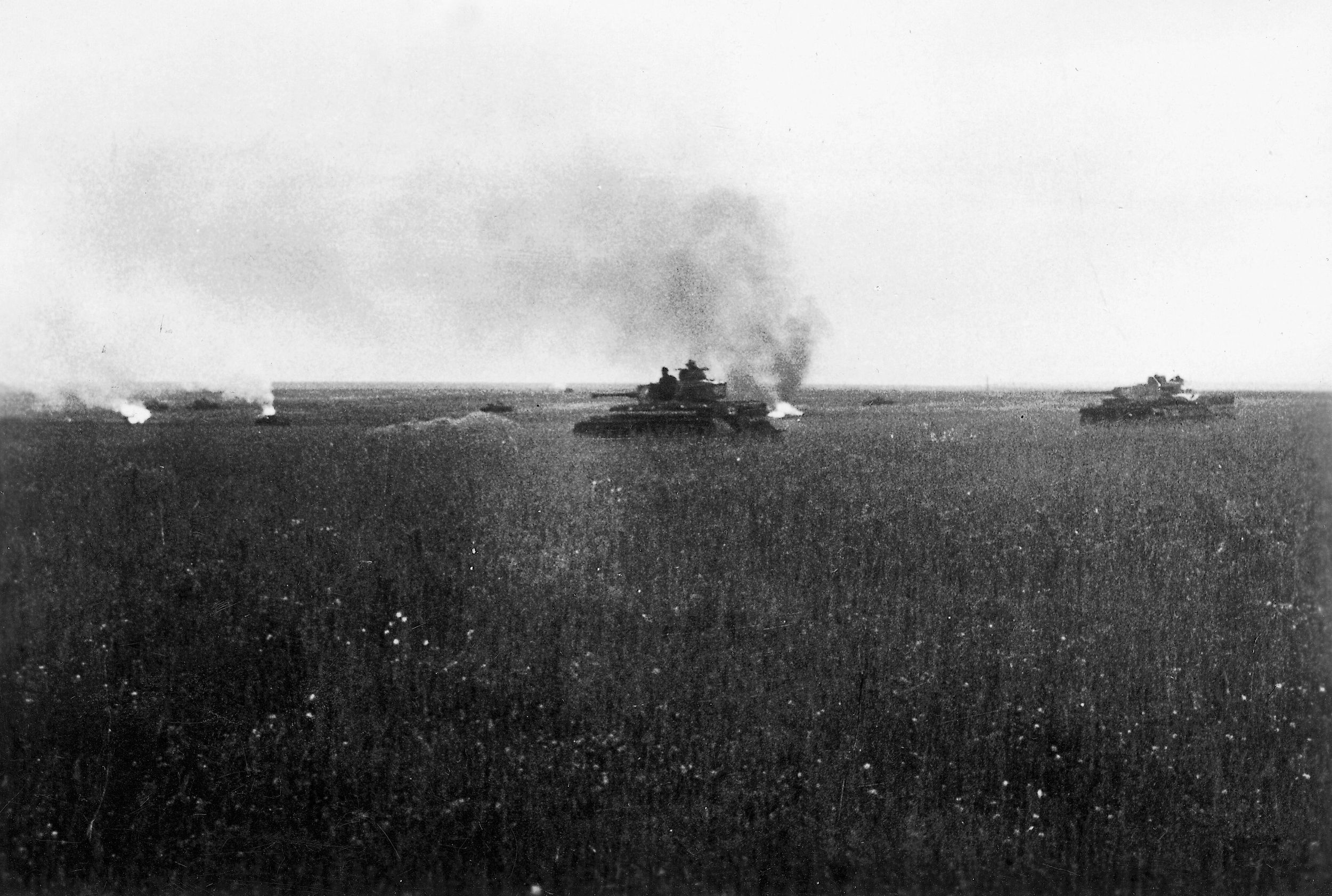 Two German panzers roll forward warily as pillars of smoke rise from disabled armored vehicles. Kursk pitted large German and Soviet tank formations against one another. The fighting at Prokhorovka, nicknamed the Gulley of Death, was particularly bitter.
