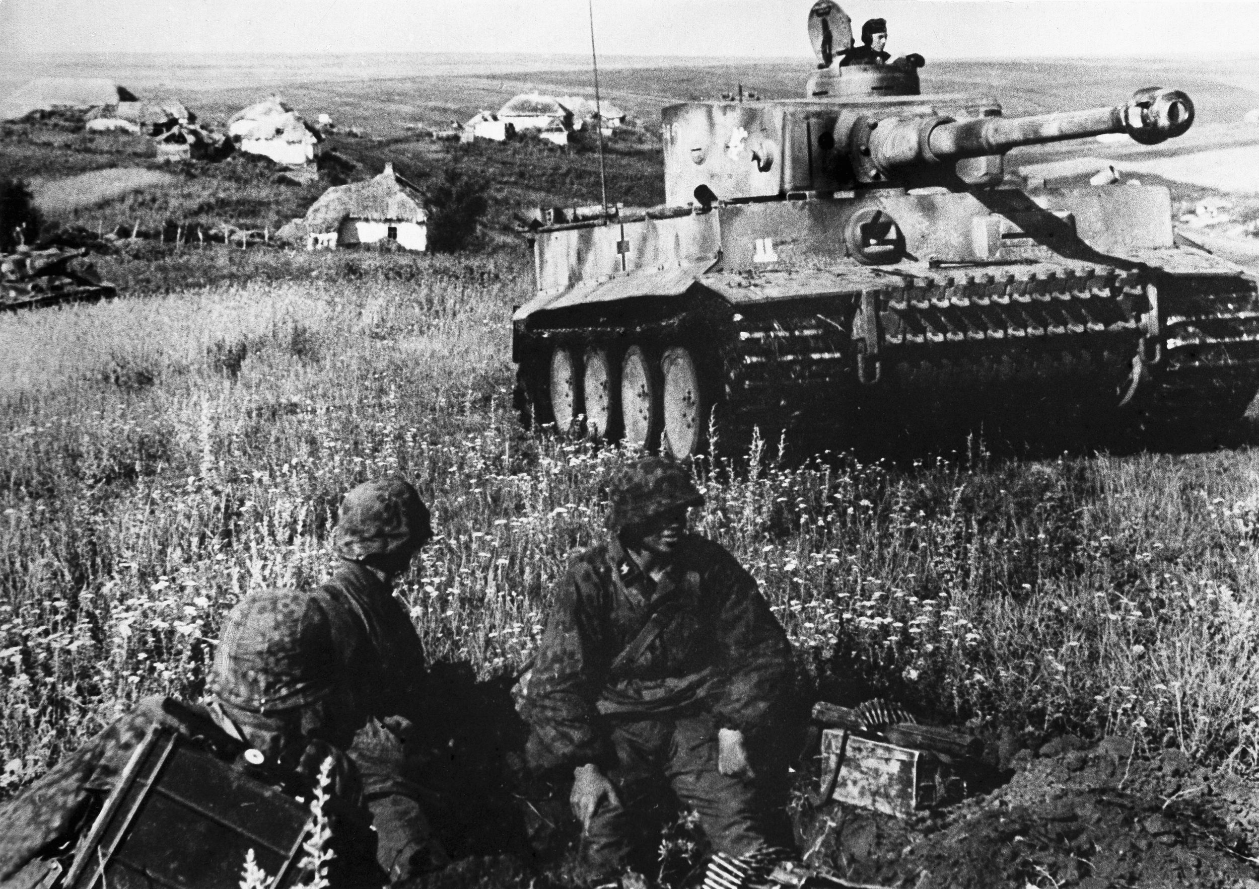 A pair of German panzergrenadiers manning a defensive position pause as a mammoth Mark VI Tiger Tank rumbles past. The open steppes of Russia proved ideal country for the maneuverability of tanks and armored formations. 