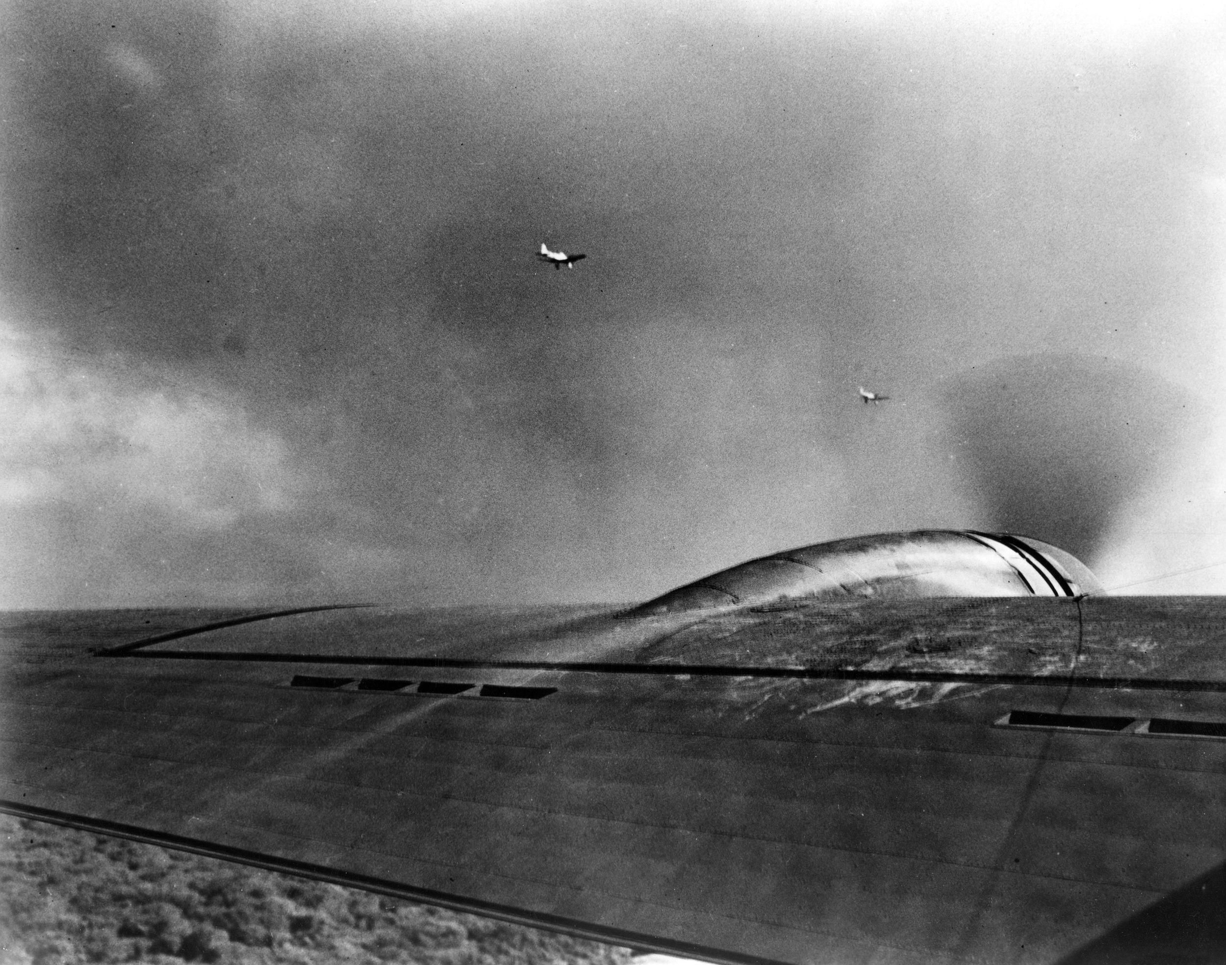 A pair of Japanese Aichi D3A “Val” dive bombers flies near the B-17E bomber piloted by Lieutenant Karl T. Barthelmess in this photo taken by Sergeant Lee Embree. The American plane was one of several B-17s from the 38th Reconnaissance Squadron that were caught up in the aerial melee above Oahu.