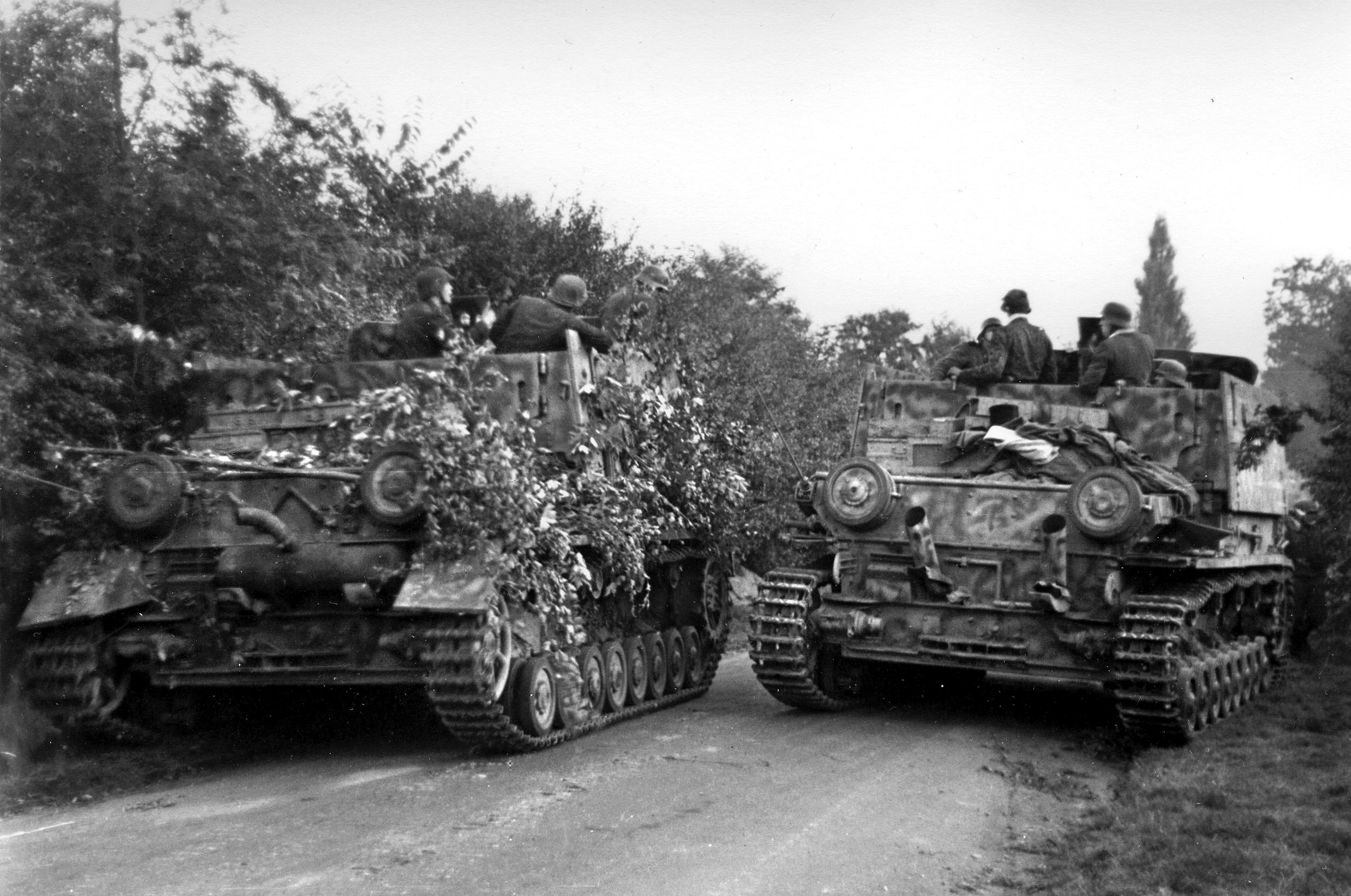 Two camouflaged German armored vehicles on a road in the Netherlands during Market-Garden. These are the Flakpanzer IV Mobelwagen, armed with a 37mm antiaircraft gun. A variant of the PzKpfw. IV medium tank, the Flakpanzer IV, or similar armored vehicles, may be what troopers of the 82nd reported as PzKpfw. V “Panthers.”