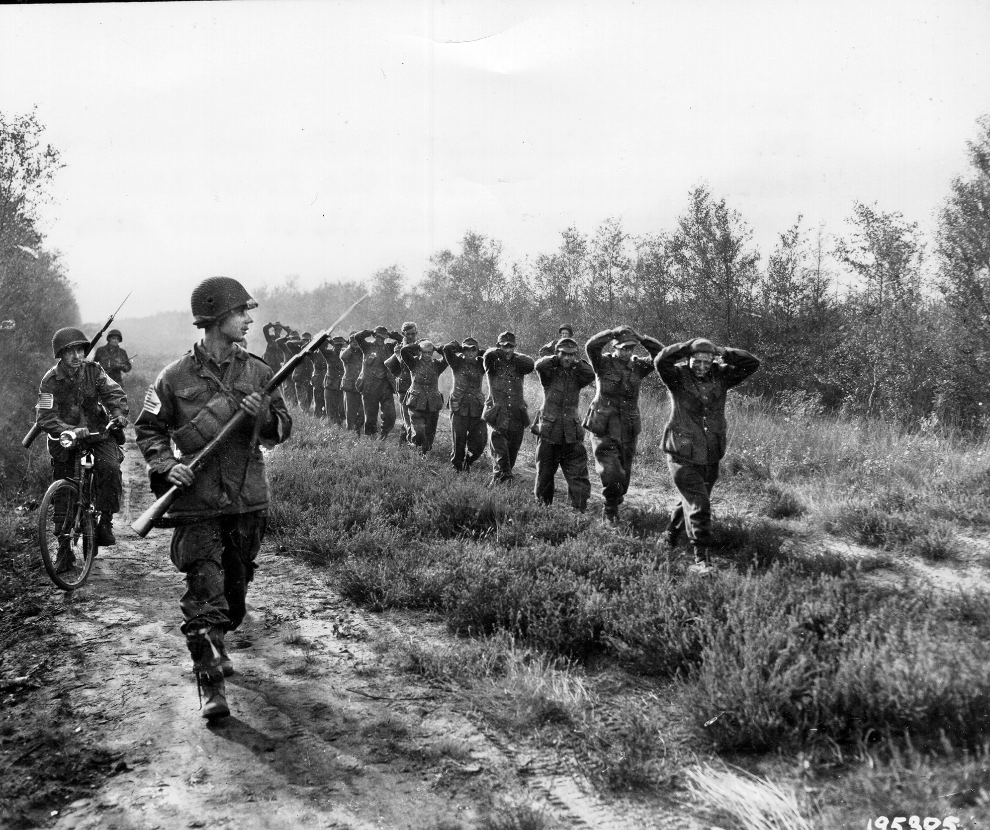 Near the Dutch town of Zon, American paratroopers guard German prisoners on the way to a collection point on September 19, 1944. 