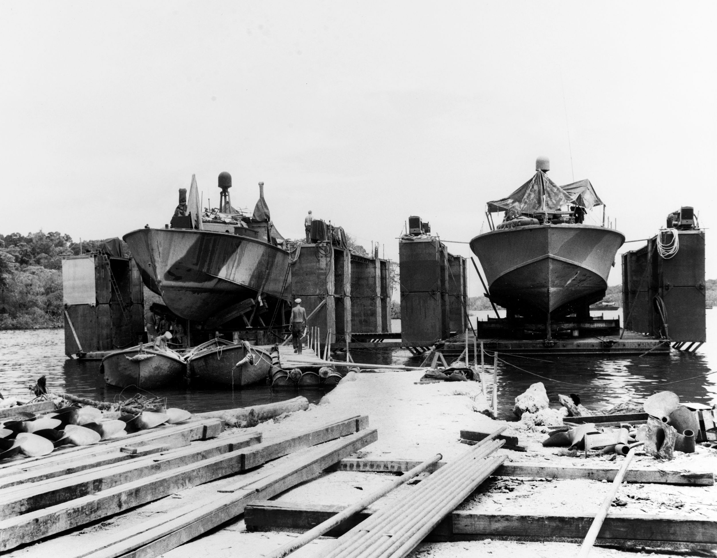 This photo depicts PT-boats in floating drydocks at the Rendova base in the central Solomons in 1943. The PT-boats were swift and heavily armed, providing firepower and surveillance during the fight to wrest control of the Solomons from the Japanese. 