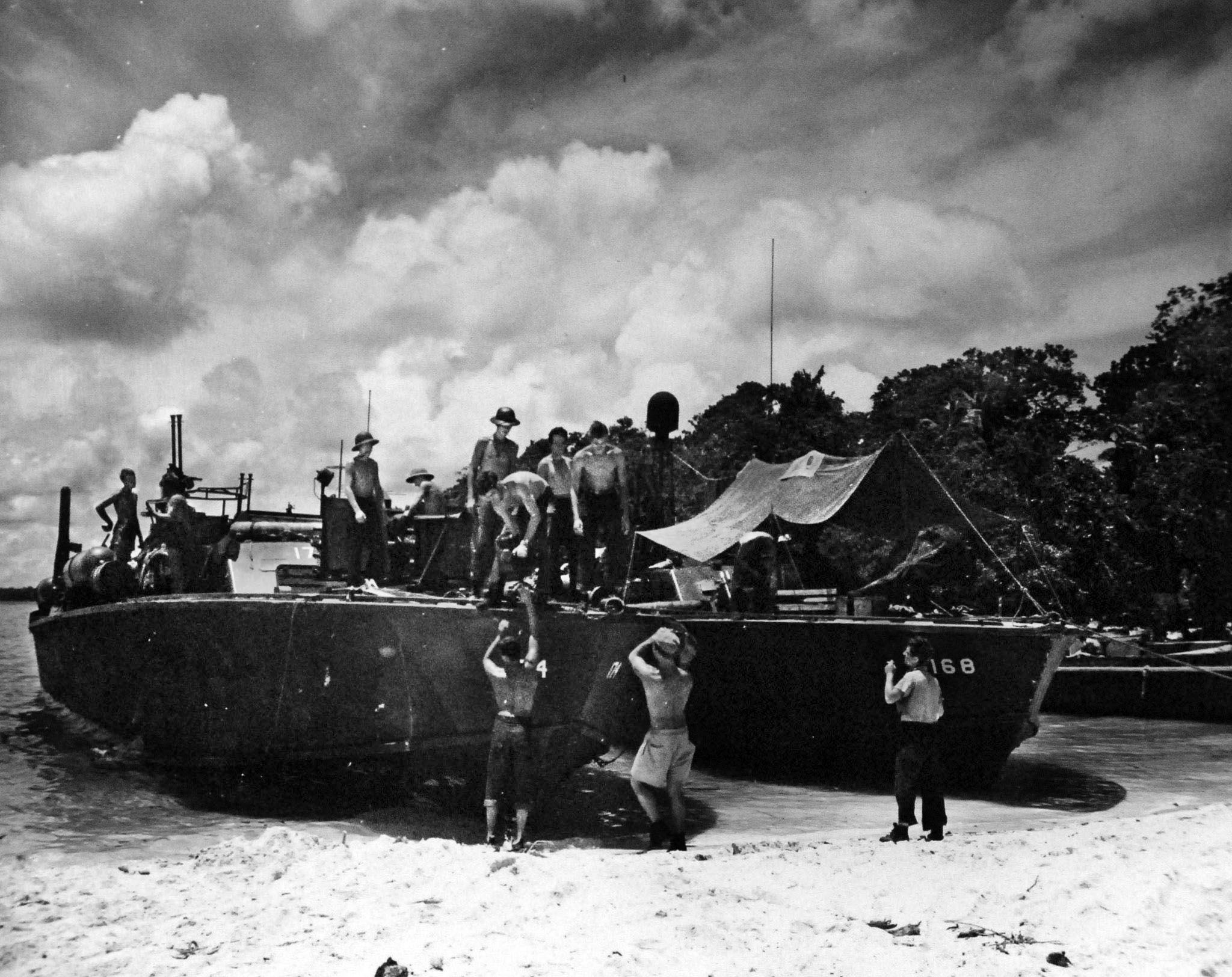 In this photo taken during World War II in the South Pacific, PT-168 is replenished with ammunition and supplies by members of her crew. A tarpaulin has been stretched across the deck aft to provide other crewmen with some relief from the tropical sun.