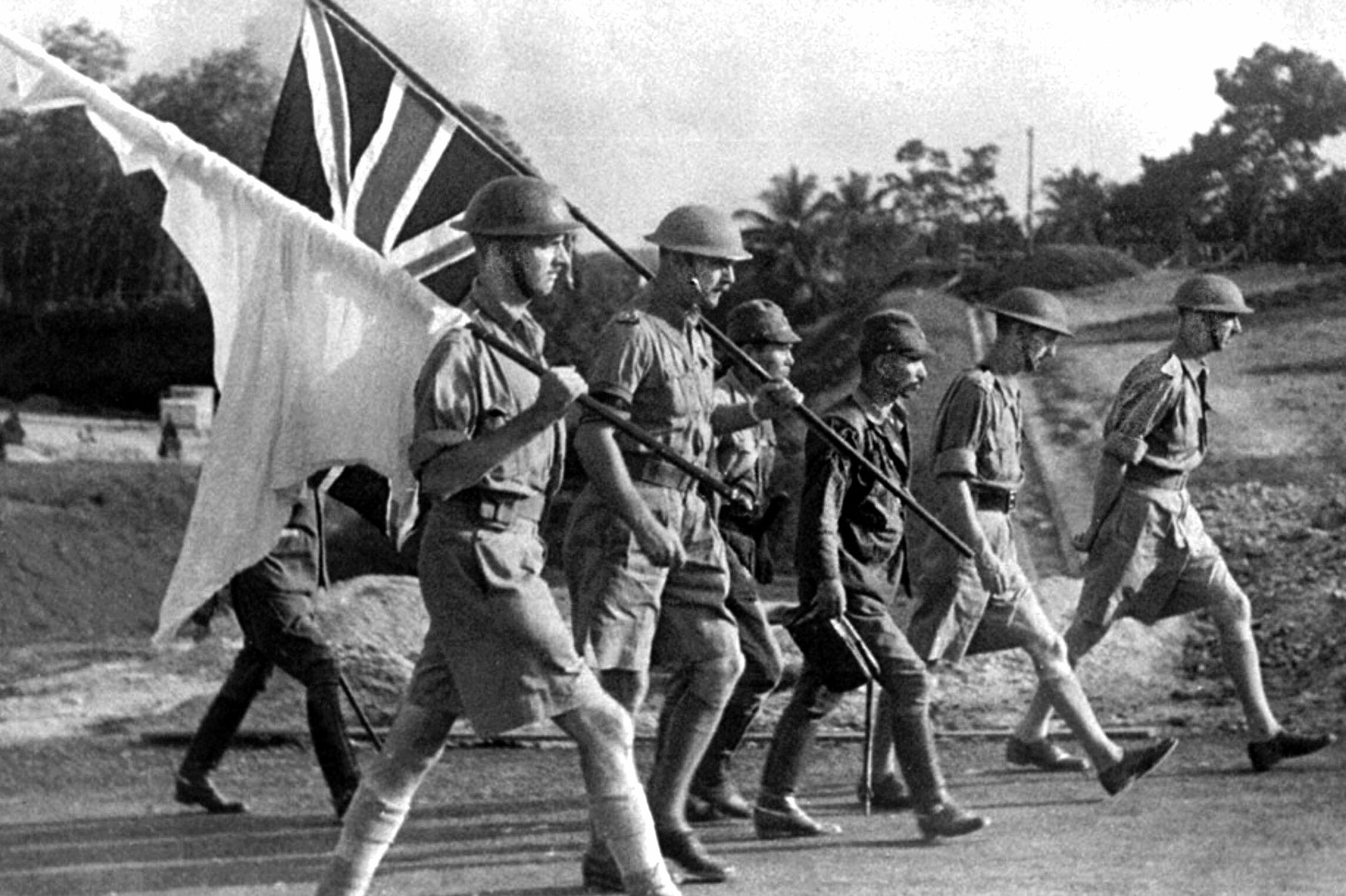 General Arthur Percival, far right, marching to the negotiating table with the surrender of Singapore imminent. Percival is accompanied by soldiers carrying the white flag of truce and the British Union Jack. Yamashita, though victorious, had already spent most of the fighting capability of his command and succeeded in taking Singapore partially with bluff and bluster.
