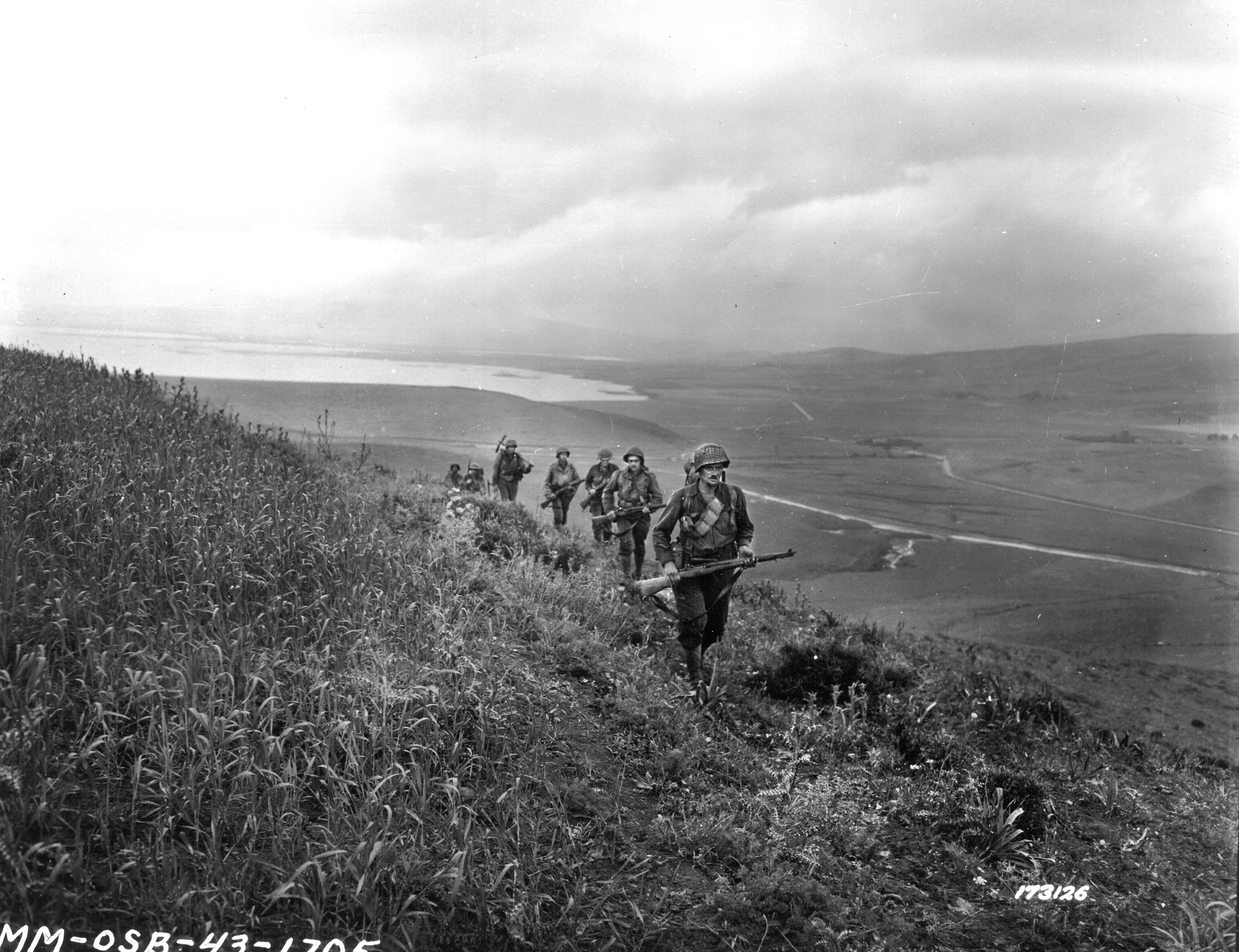 Soldiers of the 60th Infantry Regiment advance across a hill during their march to Bizerte, Tunisia, on May 7, 1943. Matt Urban and a sergeant of the regiment had to commandeer a rubber raft to get into the fighting in North Africa.