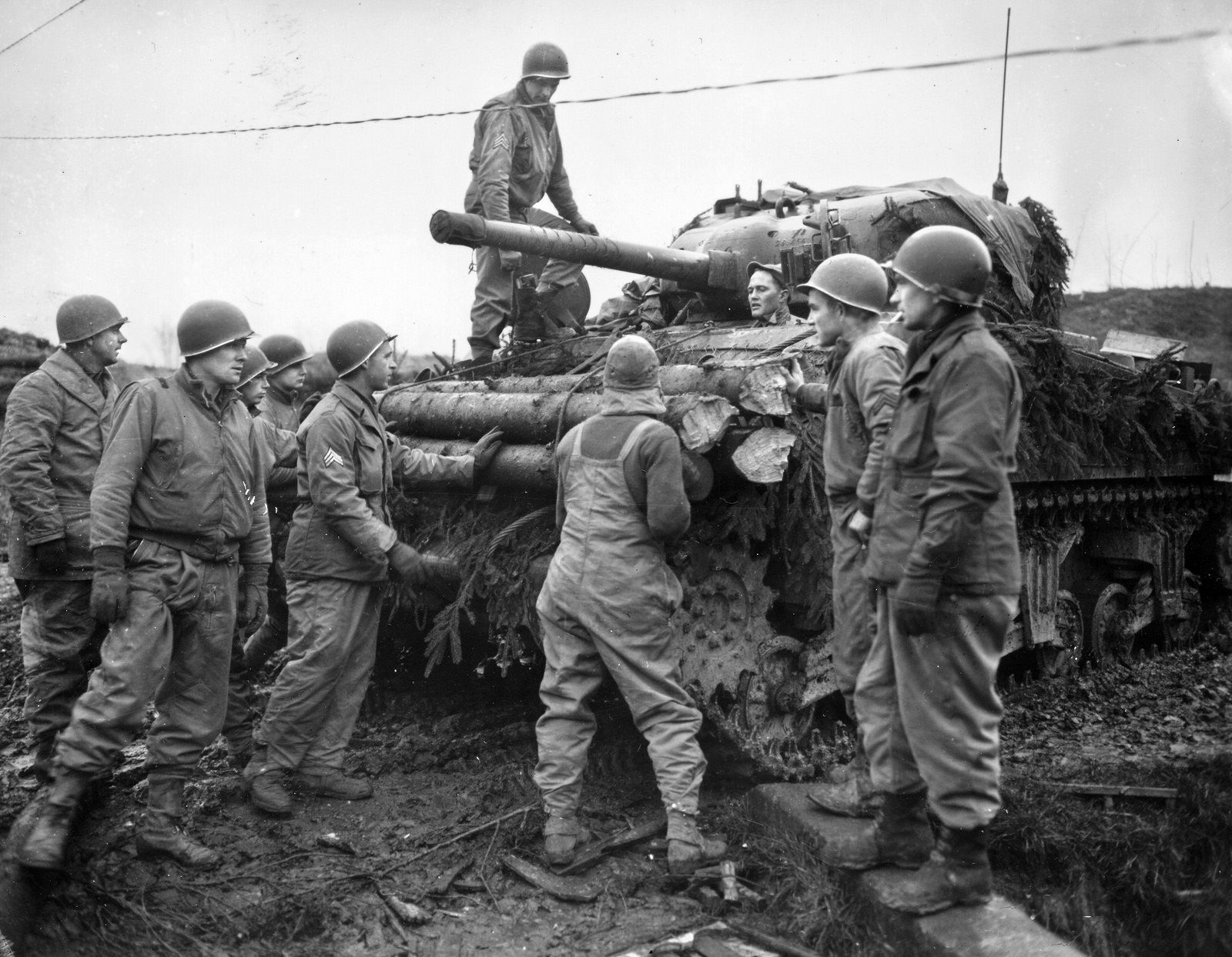 American soldiers of the 9th Infantry Division assist tankers in attaching logs to their tank as additional protection against enemy fire. Matt Urban served with the 60th Infantry Regiment, which was attached to the 1st Armored Division during the campaign in North Africa.