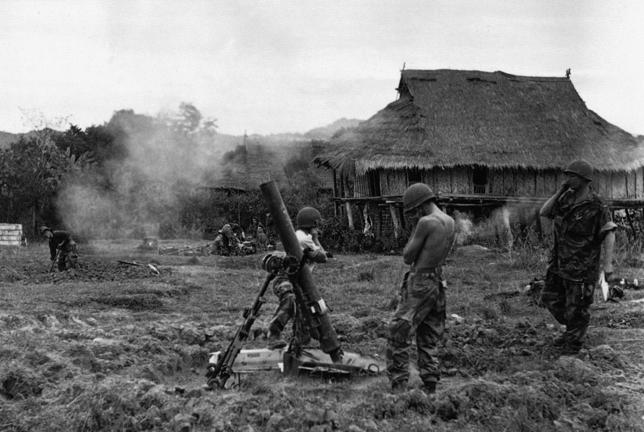 A 4.7-inch mortar line in action during Operation Castor. Huts in the background were torn down to clear fields of fire and build defenses. 