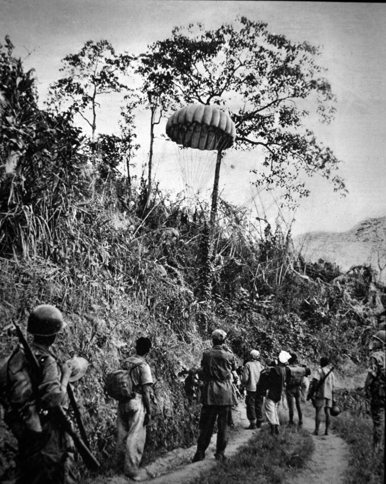 Hard-pressed French and Vietnamese soldiers wait for airlifted supplies. 