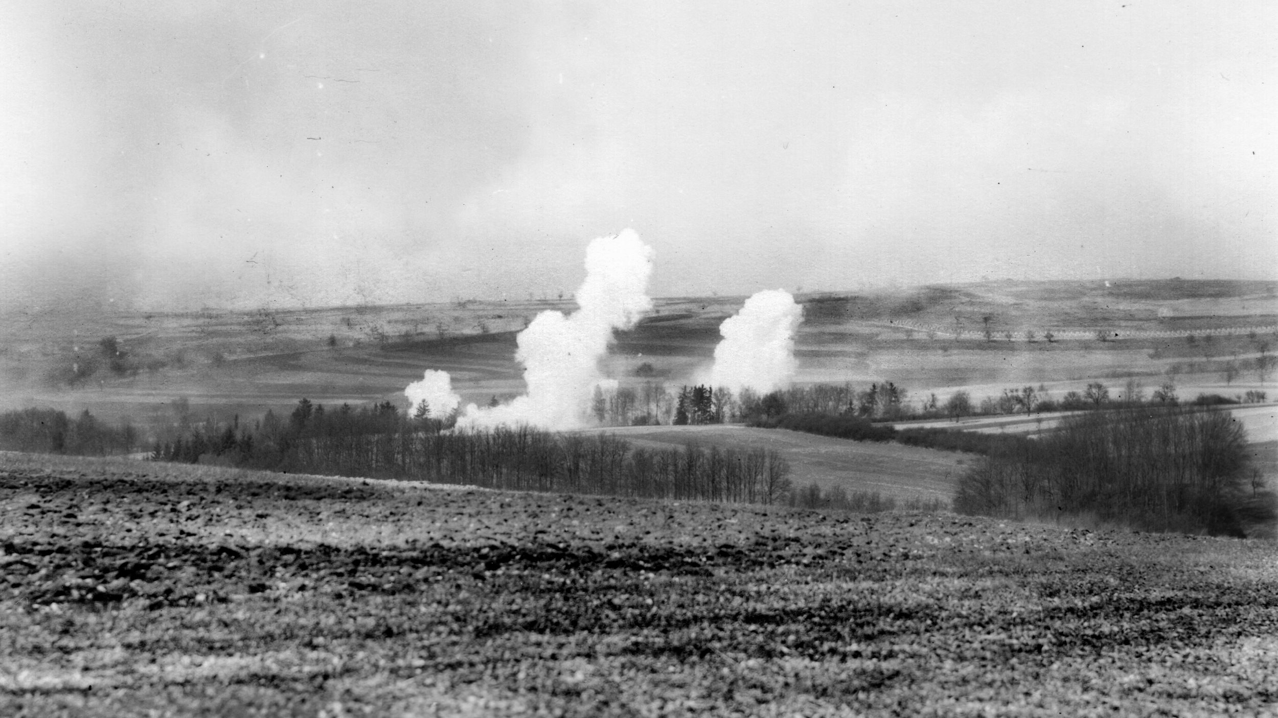 American artillery sets up a smokescreen prior to an assault against enemy-held positions near Zweibrücken. A line of dragon’s teeth obstacles (circled) is visible in the distance. 
