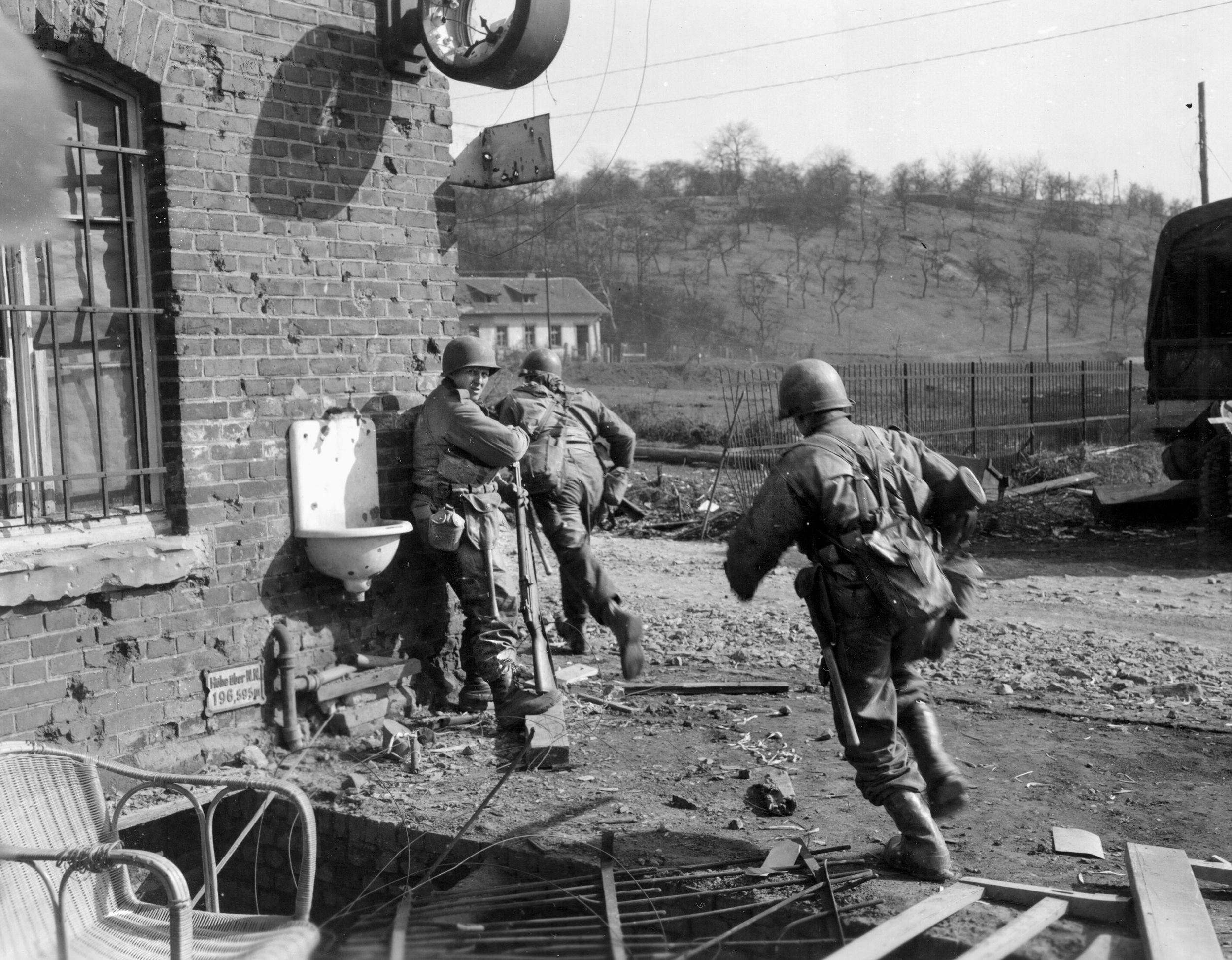 A platoon sergeant of the 276th Infantry Regiment, 70th Division, hustles his men along during action near the Saar River, March 1945.
