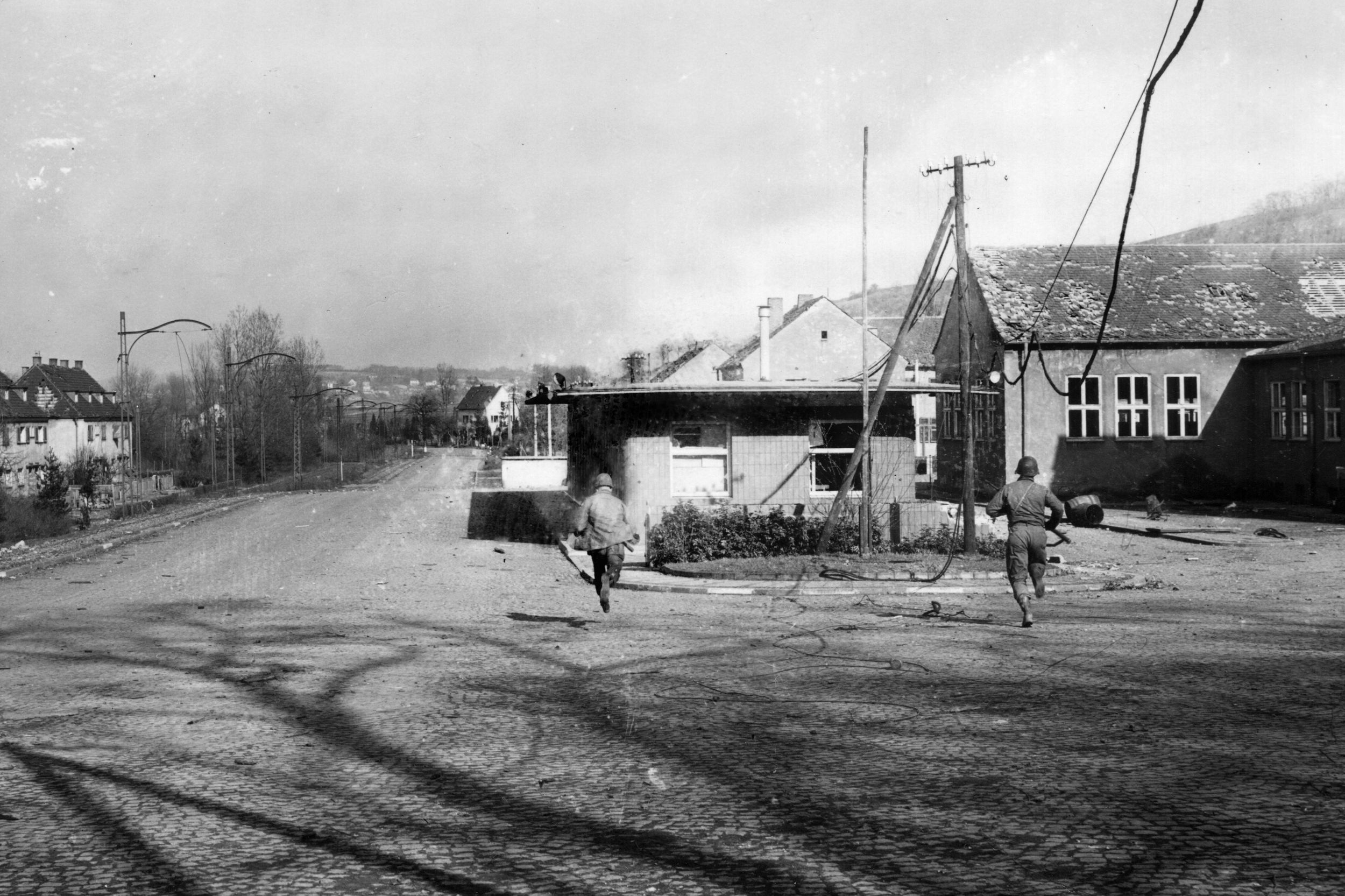 Soldiers of the 275th Infantry Regiment, 70th Division, sprint across open ground in the border town of Stiring-Wendel, south of Saarbrücken.