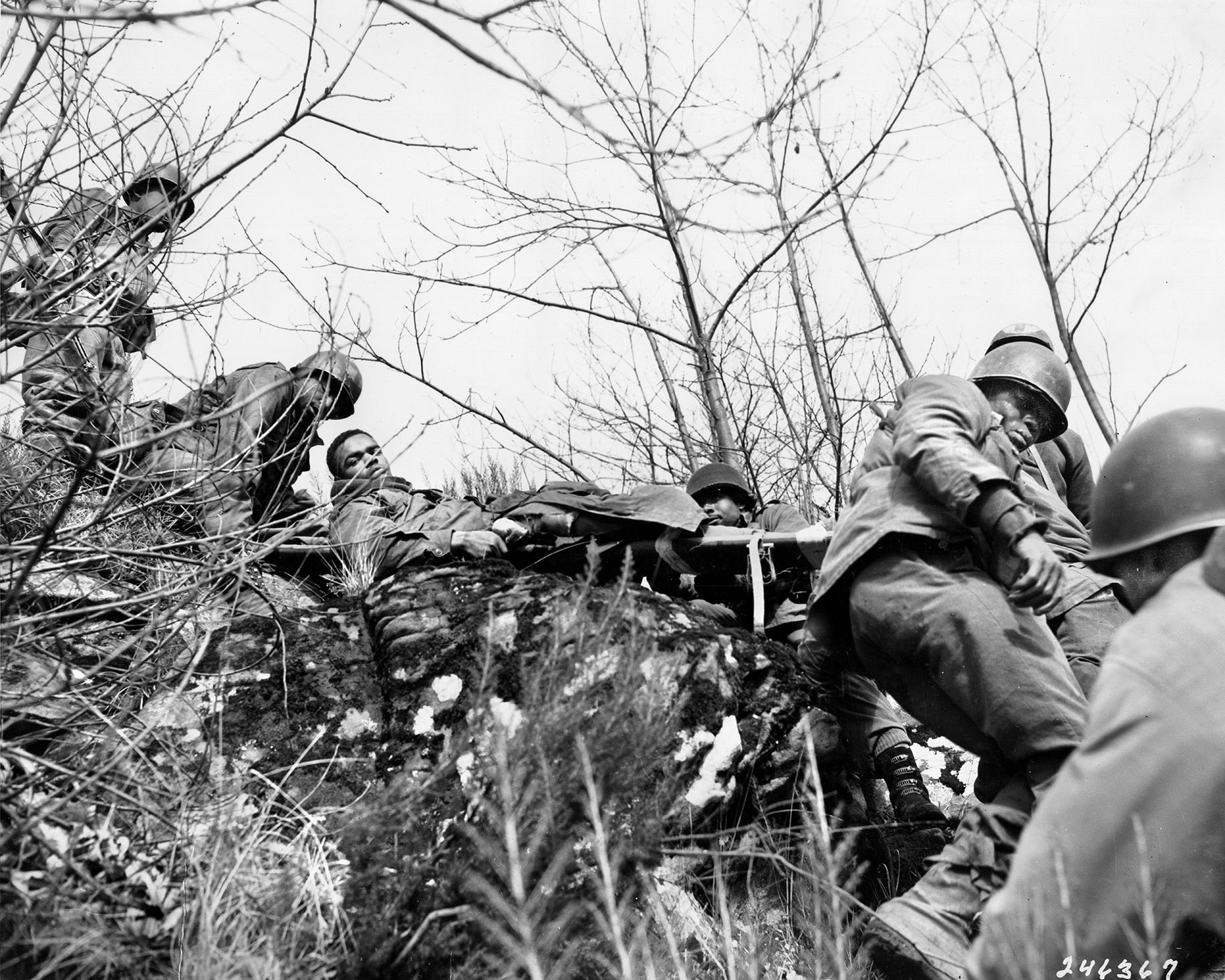 A wounded 92nd Division soldier is carried down the steep slope of a mountain in the Serchio Valley. The rugged terrain made the transporting of supplies and wounded a difficult chore.