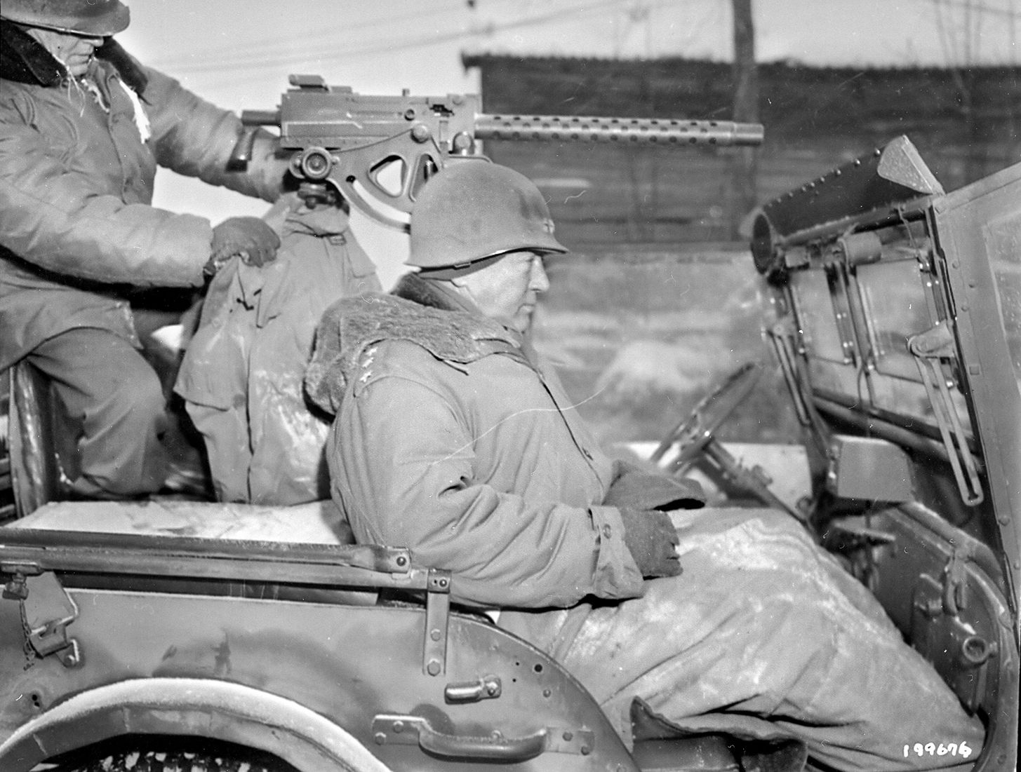 Lieutenant General George Patton rides in an open jeep on his way to visit the headquarters of the 87th Infantry Division, one of his Third Army units that he ordered to attack the Germans during the Bulge.