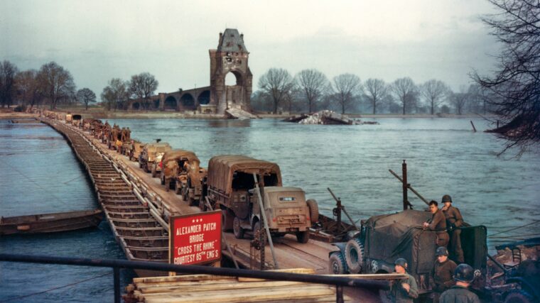 Troops of the 4th U.S. Infantry Division cross the Rhine River at Worms, March 26, 1945, on a pontoon bridge constructed by the 85th Engineer Heavy Pontoon Battalion. In background are the ruins of the Ernst Ludwig highway bridge that the retreating Germans destroyed in a vain hope of stopping the Allied advance.