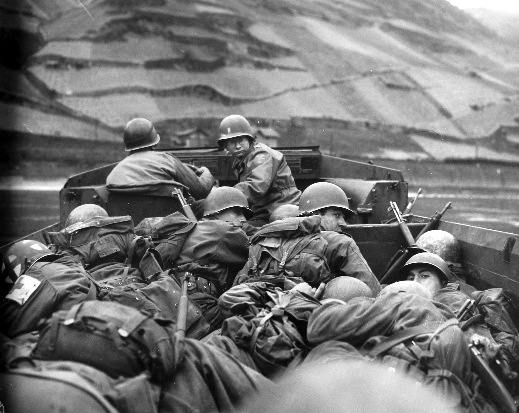 Soldiers of the 89th U.S. Infantry Division crouch low as their amphibious truck known as a DUKW comes under fire from the vineyard-covered far bank of the Rhine at Oberwesel, March 28, 1945.