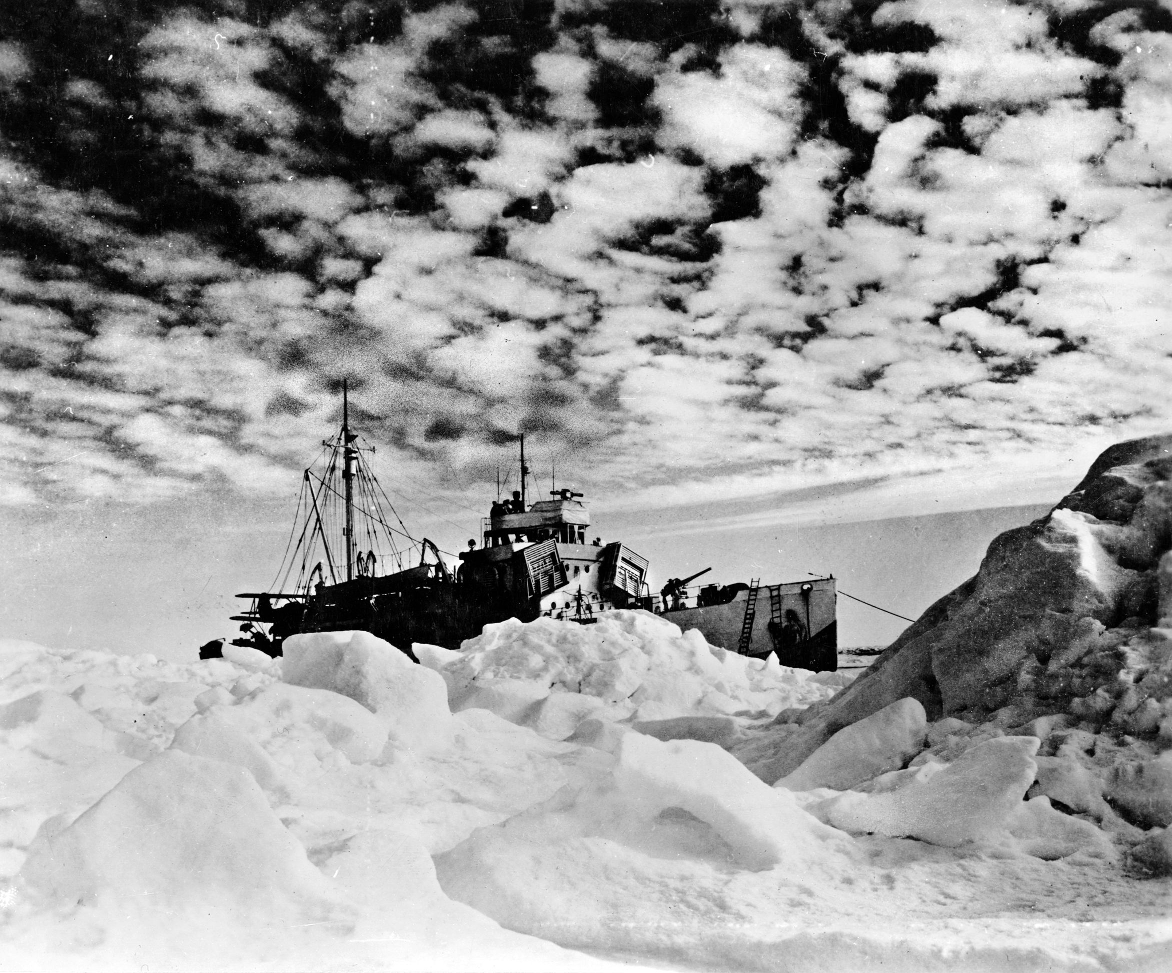 After landing a 12-man shore party that surprised three German soldiers setting up a radio station on Greenland, the Coast Guard cutter USS Northland lies at anchor amid heavy ice. Coast Guard personnel participated in action across the globe during World War II.