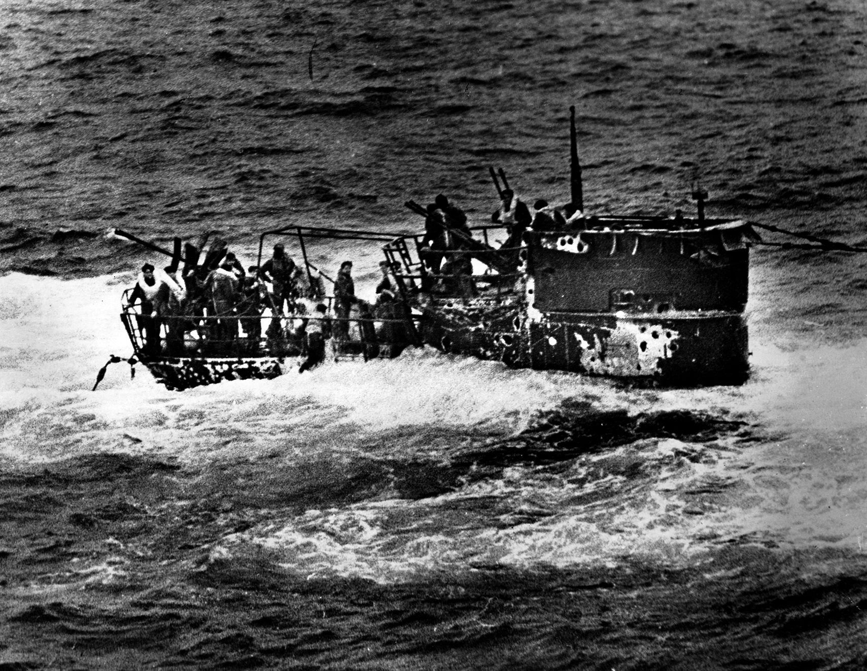 German sailors frantically make their way to the deck of the submarine U-550 after damage from Coast Guard and U.S. Navy warships forced it to the surface. Twelve Germans were taken prisoner aboard the USS Joyce, a Coast Guard destroyer escort originally built for the Navy.