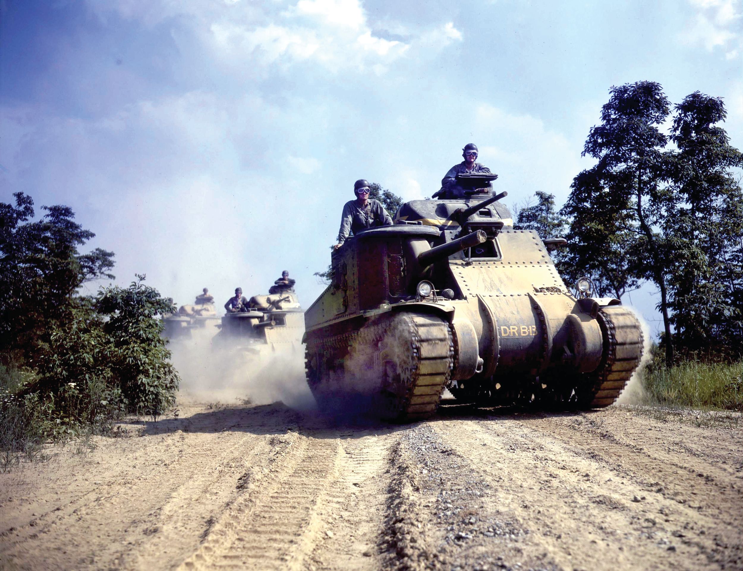 An M3 Grant tank leads a column of armored vehicles during maneuvers at Fort Knox, Kentucky, in June 1942. The Grant was a stopgap design with a sponson mounted 75mm gun.