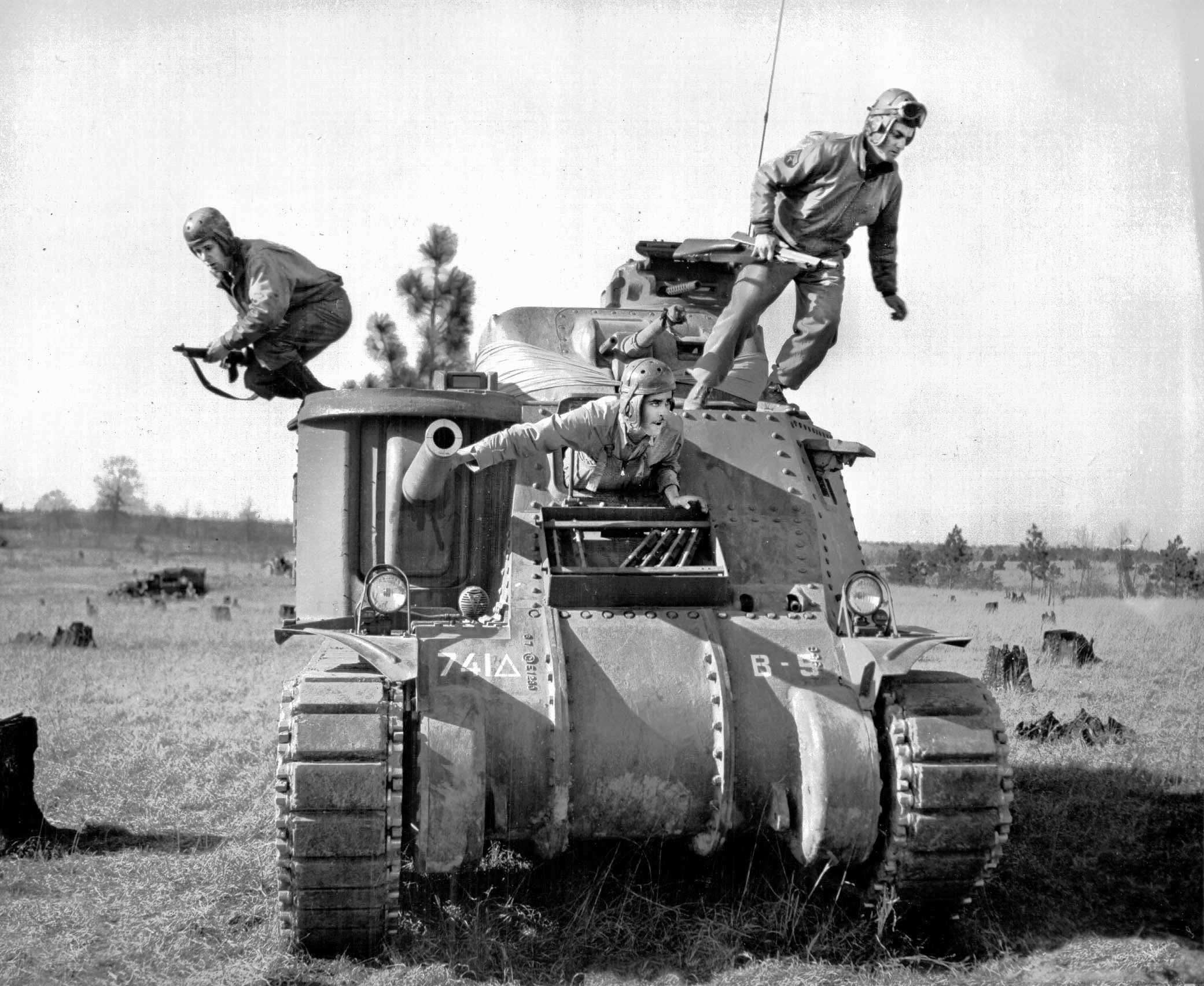 During Third Army maneuvers at Camp Polk, Louisiana, in February 1943, crewmen of the 741st Tank Battalion make a rapid exit from their Grant tank while carrying small arms.