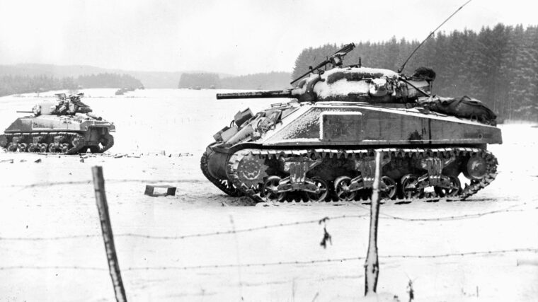 M4 Sherman medium tanks of the 35th Tank Battalion, 4th Armored Division, clear the road to Bastogne, Belgium, during the Battle of the Bulge in December 1944. The 4th Armored Division was the spearhead of the Third Army drive north to relieve the 101st Airborne Division holding Bastogne, a vital crossroads.