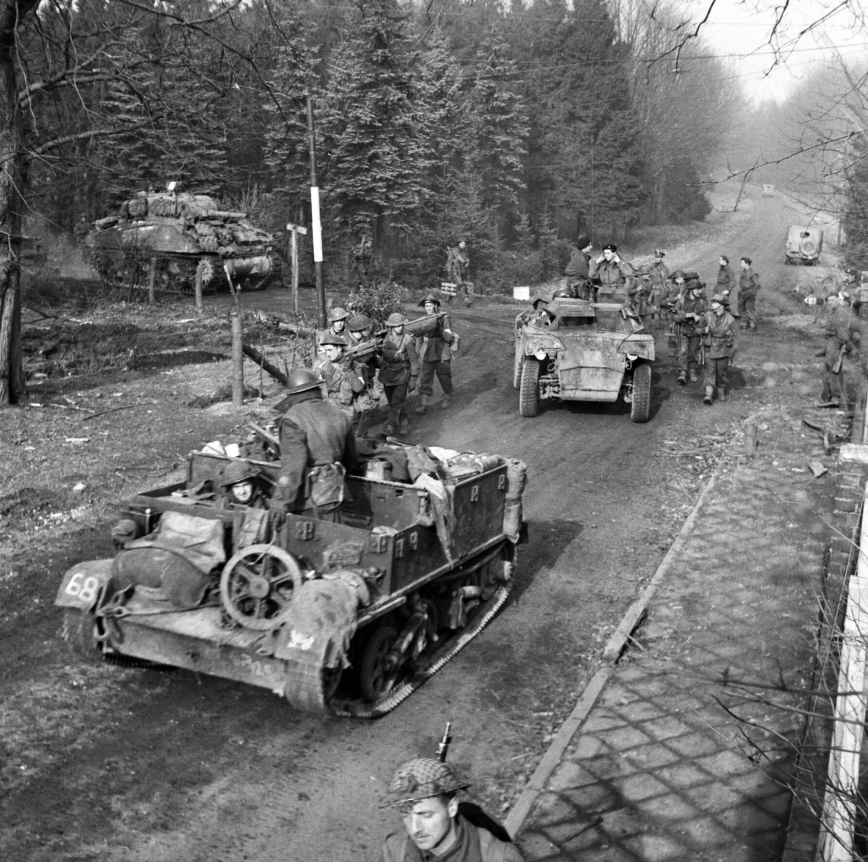 British soldiers of the 43rd Wessex Division move aside on the road to Goch, Germany, as a universal carrier, Humber scout car and Sherman tank go ahead on Febrary 17, 1945. 