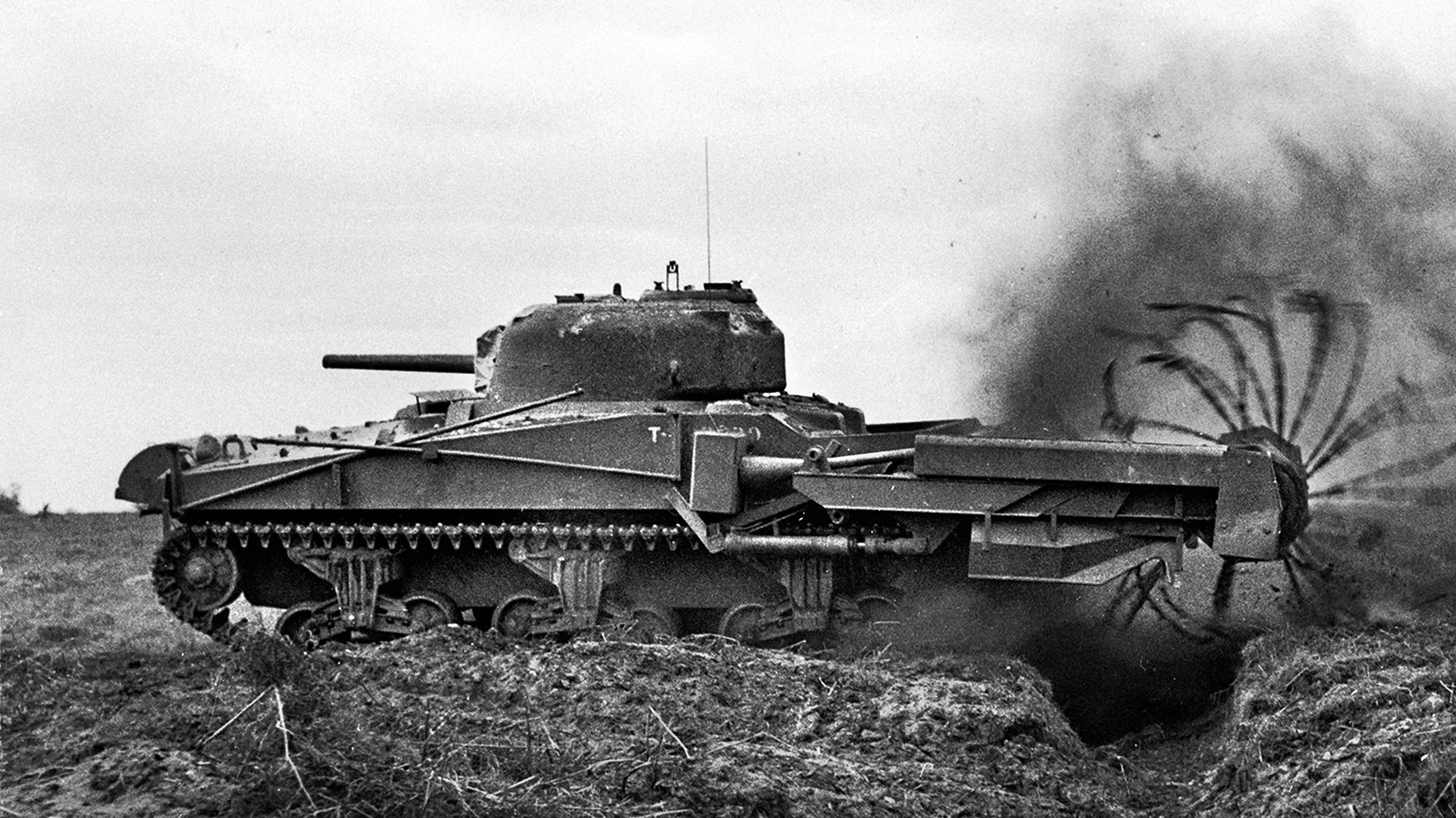 A problem solving engineer, Major General Percy Hobart developed the “Crab” from a Sherman tank with a chain flail attached to detonate mines.  His “Crocodile,” fashioned from a Churchill tank, was 
fitted with a flamethrower and towed a 400-gallon armored fuel tank for it.
