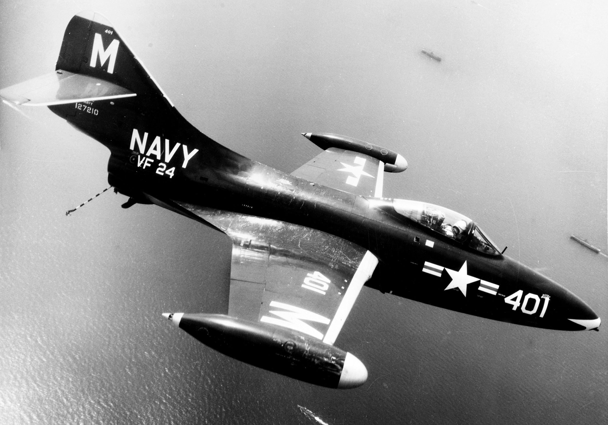 Navy F9F-2 Panther of Fighter Squadron 24 (VF-24) flies over ships of Task Force 77 during operations off North Korea in July, 1952.