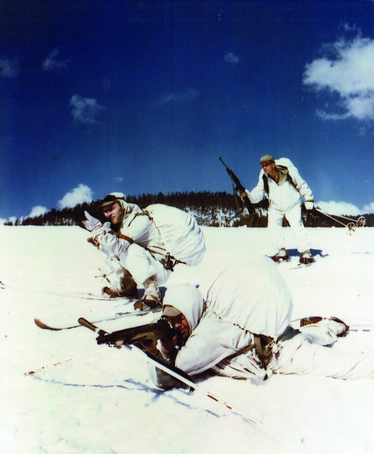 Wearing white camouflage and aiming their weapons toward enemy positions during a training exercise in 1945, these soldiers on skis are preparing for another operation in the alpine area of northern Italy. 