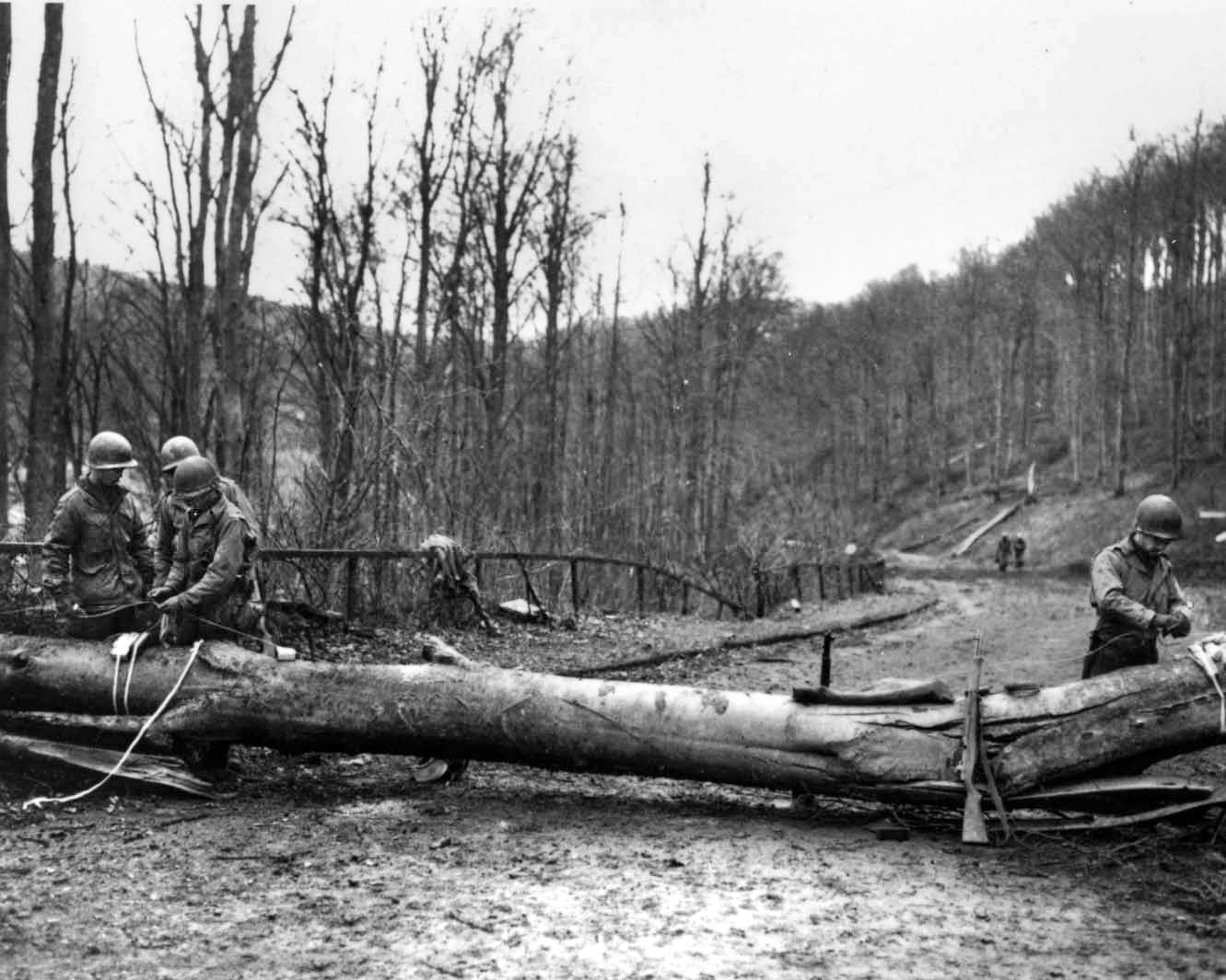 While attempting to slow the German penetration during the Battle of the Bulge in December 1944, American soldiers establish a roadblock. The U.S. 80th Infantry Division played a key role in the relief of Bastogne during the great battle.