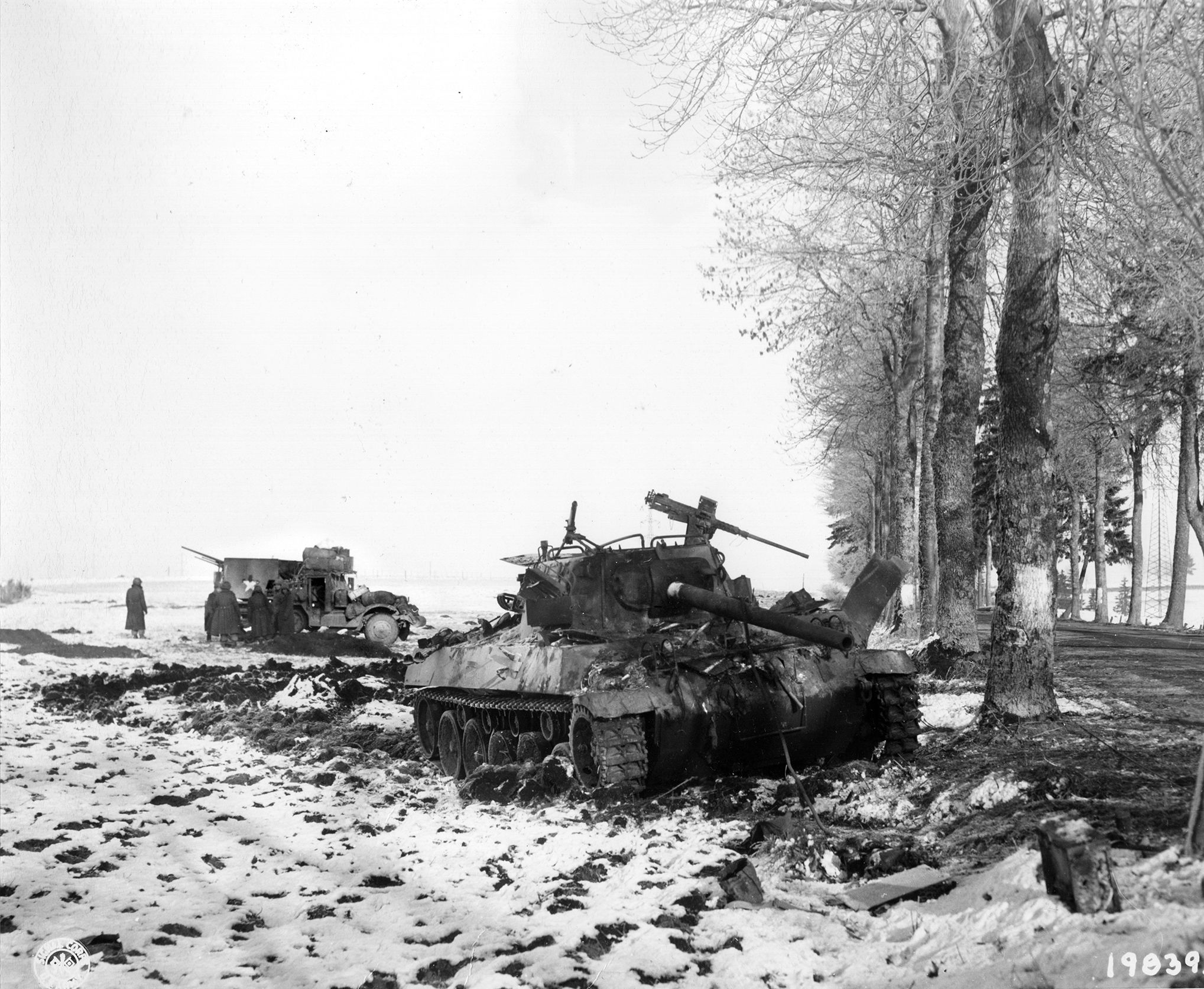 German artillery fire knocked out this M4 Sherman medium tank and another vehicle during the bitter fight for control of Bastogne, a village in Belgium and a vital road nexus. American forces held Bastogne, stifling German plans, until relieved.