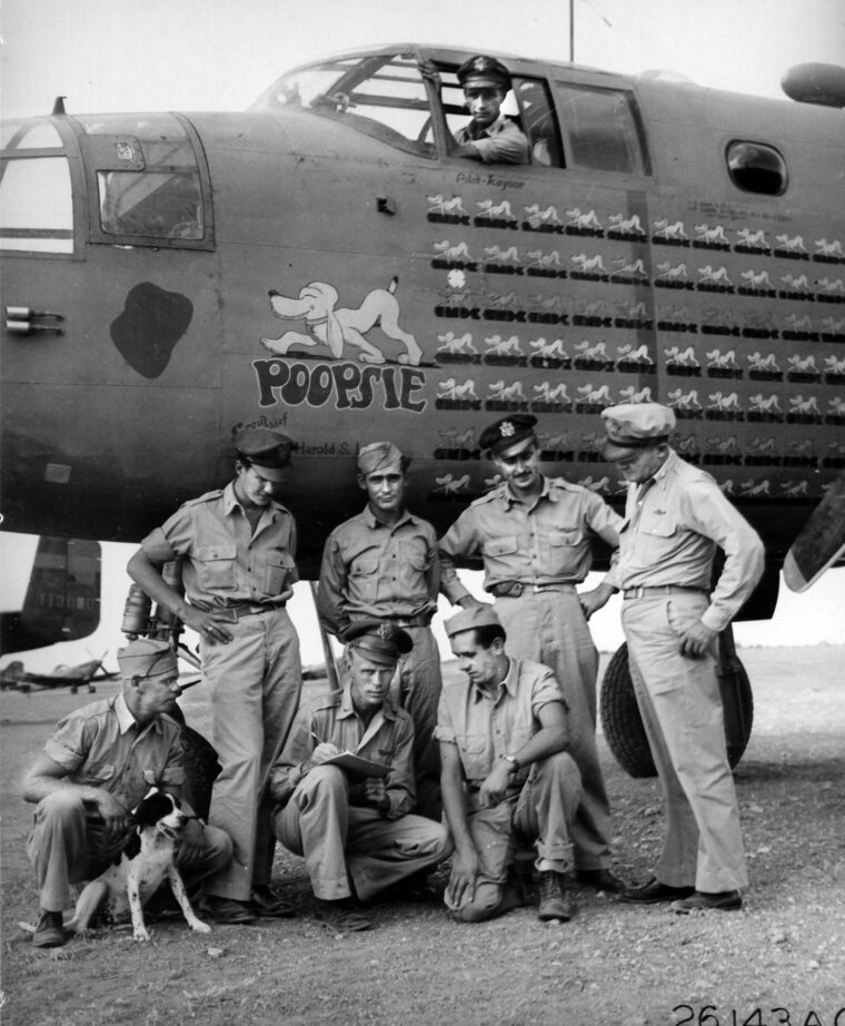 Posing at a U.S.Army Air Forces base in North Africa, the crew of the B-25 Mitchell nicknamed “Poopsie” has completed 50 missions and is headed home to participate in a War Bonds campaign. Kneeling, left to right: T/Sgt. Joseph R. Toy, 1st Lt. Curtis B. Hasty, T/Sgt. Theophil S. Sidlick. Standing, from left: 1st Lt. Oscar R. Daume, S/Sgt. Charles E. Wray, 2nd Lt. Walter C. Piasecki. Robert B. Kayser, Commanding General of the medium bombardment wing, is in the pilot’s seat.