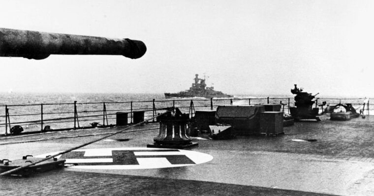 The Kriegsmarine pocket battleship Admiral Scheer is photographed from the deck of the heavy cruiser Prinz Eugen en route to Norway during Operation Cerberus—the “Channel Dash”—in February 1942. Aircraft recognition markings are visible on the deck of Prinz Eugen, as is a portable 20mm antiaircraft gun mounted further aft.