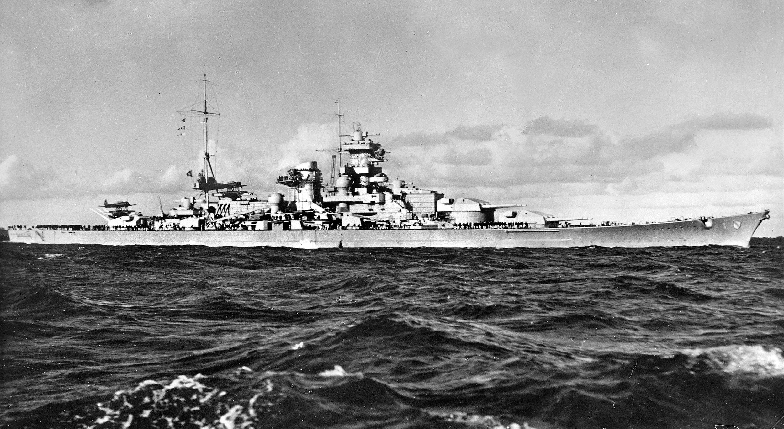 The sleek battlecruiser Scharnhorst is shown at sea during World War II. Scharnhorst and its sister ship Gneisenau both struck mines during Operation Cerberus but completed the dangerous transit of the English Channel in February 1942 without further damage.