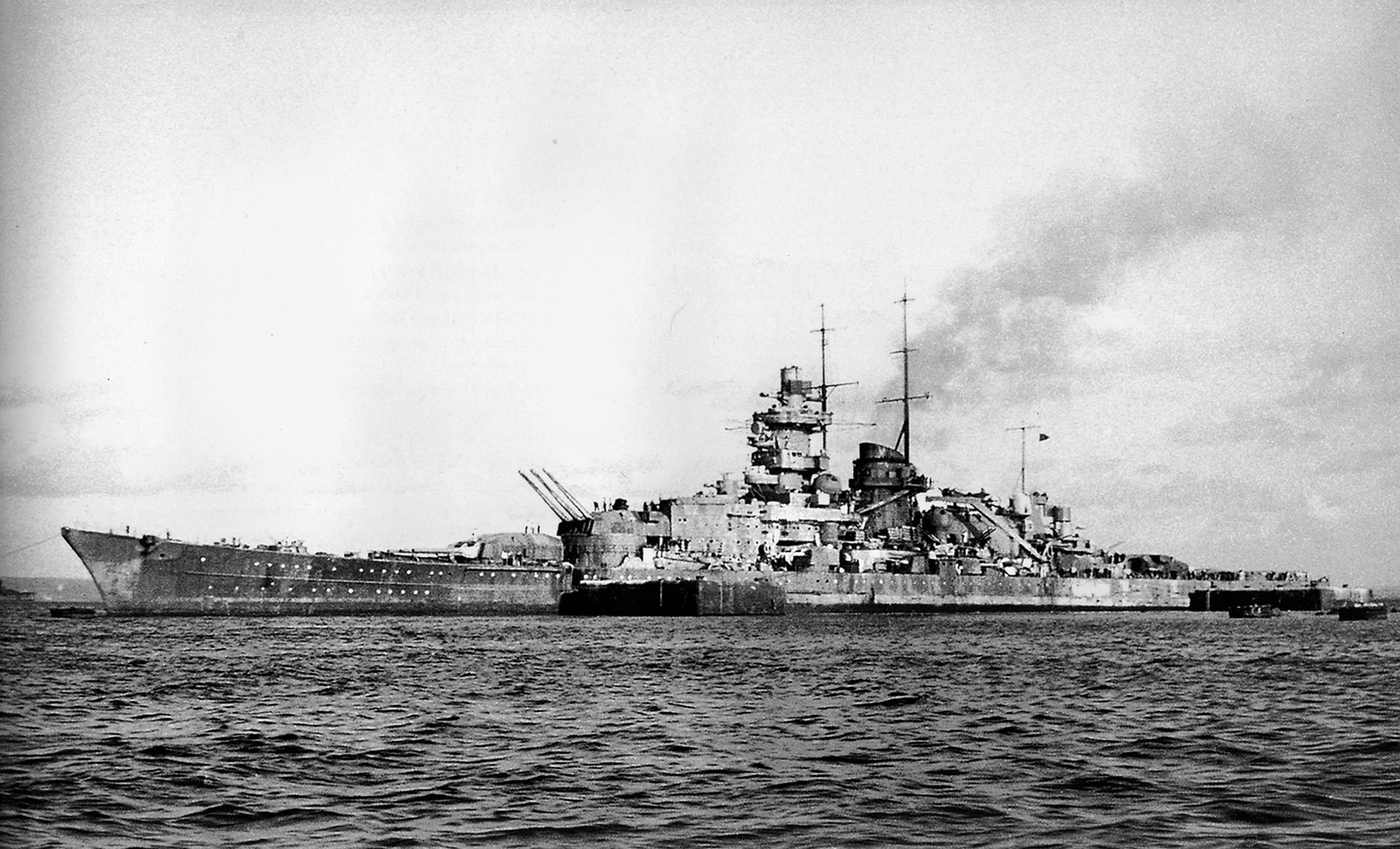 The battlecruiser Gneisenau is photographed from the deck of an escort ship returning to port in December 1941, following Operation Berlin, a mission to ravage British merchant shipping. Gneisenau was accompanied by the battlecruiser Scharnhorst during Operation Berlin and later in Operation Cerberus, the daring but successful “Channel Dash” of February 1942. 