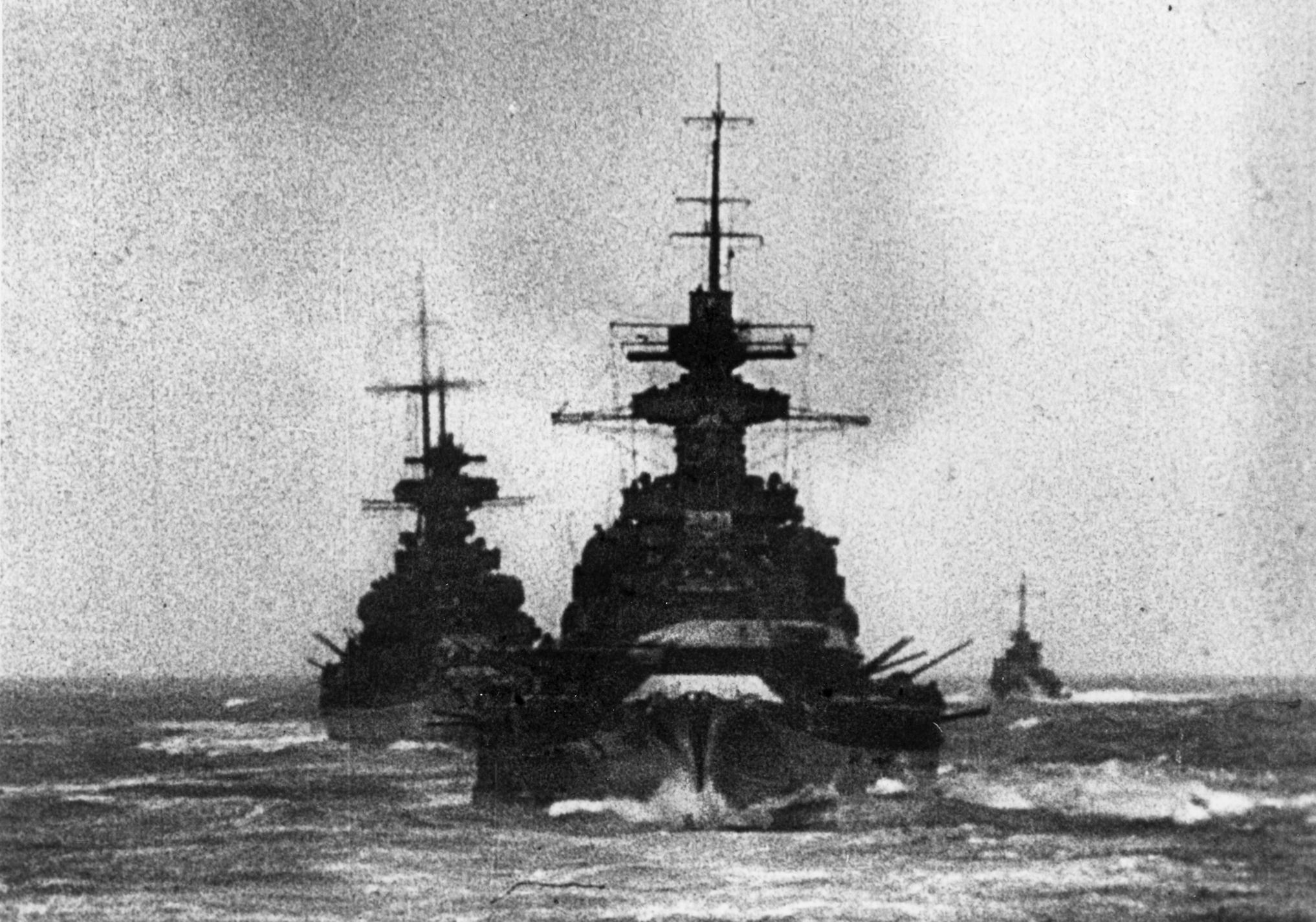 The German battlecruisers Scharnhorst and Gneisenau sail in line while firing their main batteries. This photo is believed to have been taken during Operation Cerberus, the “Channel Dash” of February 1942, during which the warships departed the French port of Brest and arrived in Germany at the port of Wilhelmshaven. They were damaged by magnetic mines during the hazardous journey, but British efforts to sink them outright, along with the heavy cruiser Prinz Eugen, proved futile.