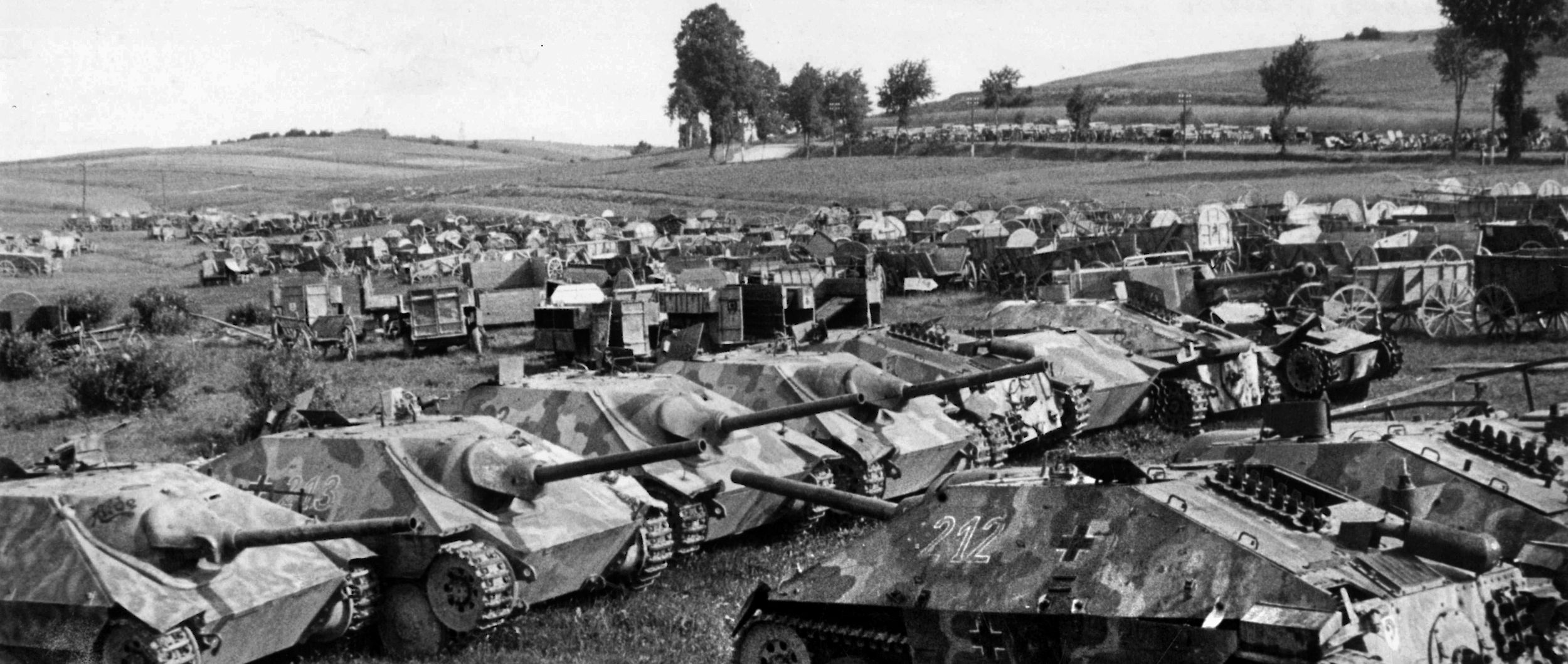 These captured armored vehicles were surrendered to the Soviet Red Army in 1945. Among them are several examples of the Panzerjager 38(t) assault gun, popularly known as the Hetzer and built on the Czech 38(t) chassis. Also built on the Czech 38(t) chassis, a Marder III is visible at right. Horse-drawn wagons are shown toward the rear.
