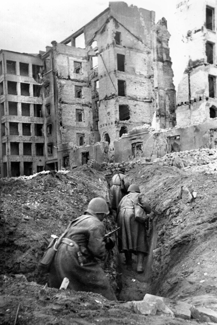 Soviet soldiers crouch as they move through a trench during the vicious street fighting that occurred in Stalingrad. The fight for the city lasted for months as the Red Army encircled the German Sixth Army inside it.