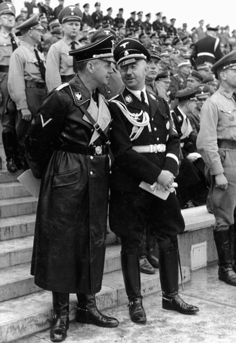 Heinrich Himmler (right) converses with a fellow SS officer during Reichsparteitag Großdeutschland (National Party Day) in August 1938.
