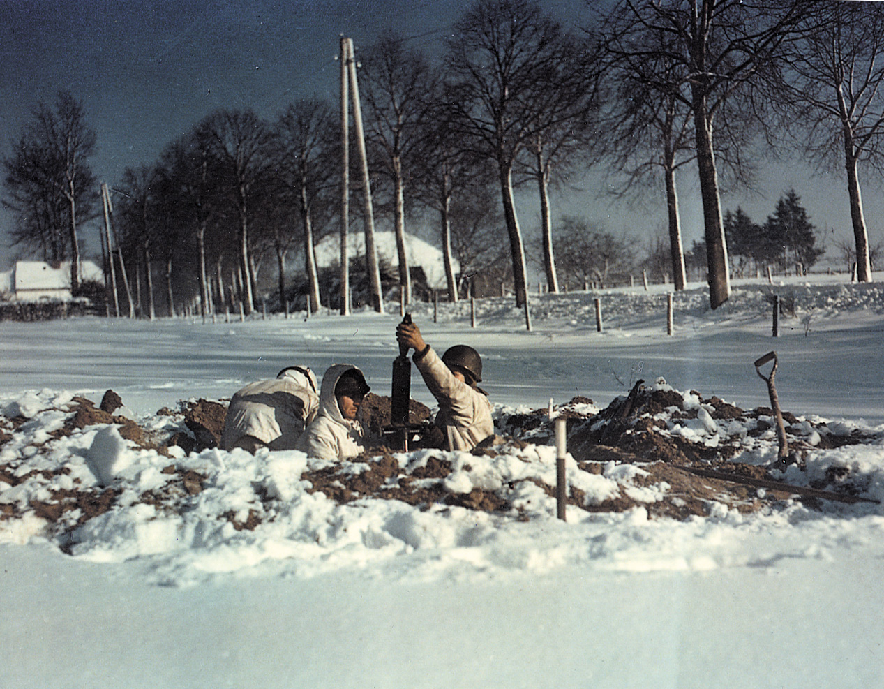 With St. Vith taken, a mortar team prepares to fire on the retreating Germans. Digging holes in the frozen terrain proved a difficult task, and some men resorted to blasting holes with dynamite to loosen the soil.