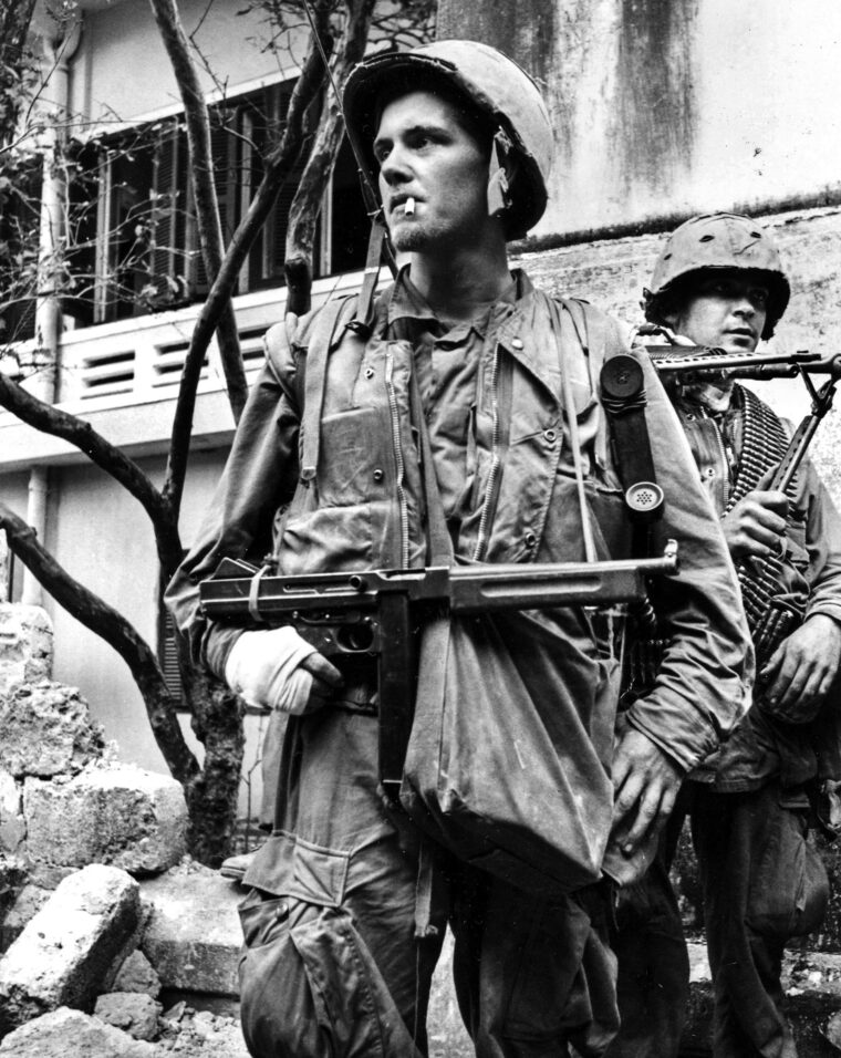 An unidentified U.S. Marine with a bandaged hand carries an M1 Thompson submachine gun during the Tet Offensive in February 1968 in Hue City.