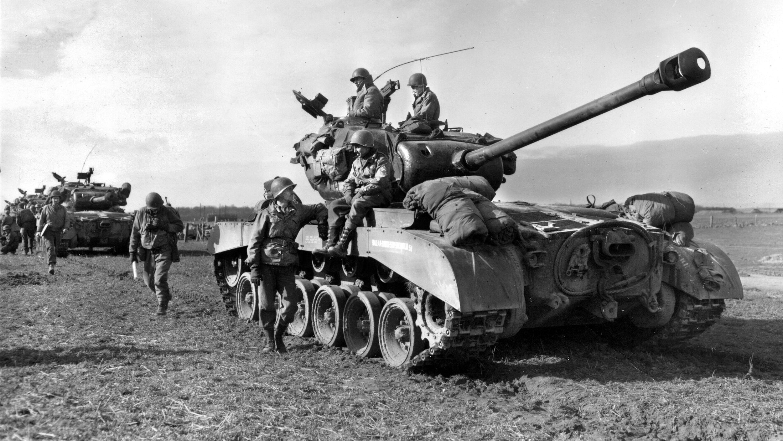 Crews of the 14th Tank Battalion, 9th Armored Division, await with their new M-26A3 Pershing tanks for the word to advance in early March. Elements of the unit commanded by 2nd Lt. John Grimbal were among the first to arrive at the Ludendorff Bridge with four of the new heavy tanks.